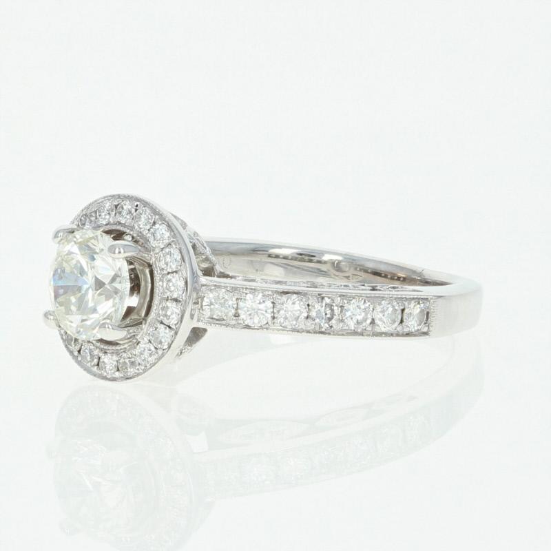 Begin the next chapter of your love story with this breathtaking engagement ring! Composed of high purity 18k white gold, this piece showcases a radiant diamond solitaire that is beautifully encircled by a diamond halo and highlighted by sparkling