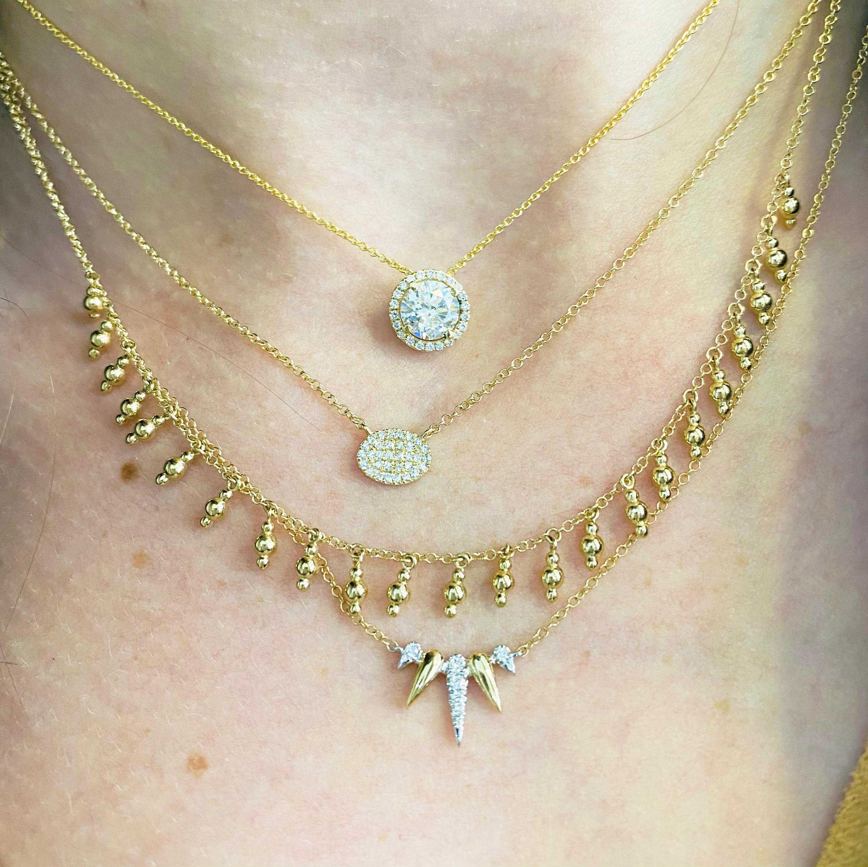 This gorgeous .94 carat center diamond set inside a brilliant white diamond halo and delicately hanging from a 14k yellow gold chain is sure to put a smile on anyone's face! The adjustable chain with an adorable hidden heart design on this necklace