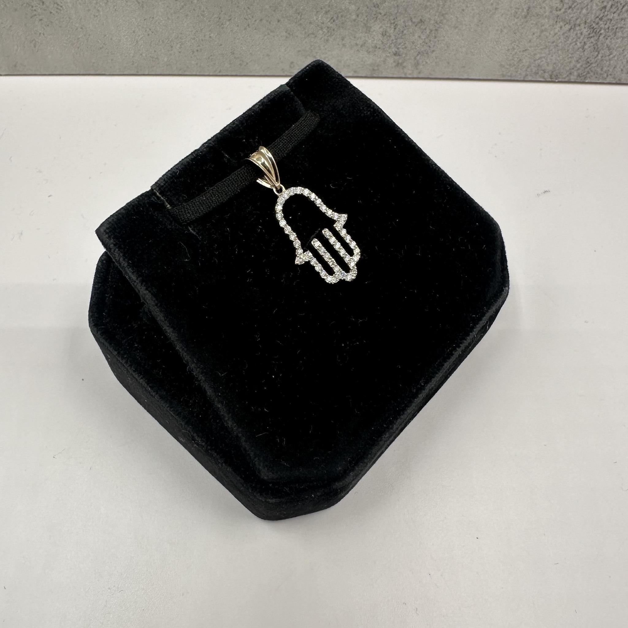 Dieser wunderschöne Diamant-Hamasa-Anhänger aus 14-karätigem Gelbgold besteht aus 0,35 Karat (ctw) natürlichen runden Diamanten der Farbe GH und der Reinheit SI. Der Anhänger mit den Maßen von ca. 19x14 mm (ohne Bügel) hat die Form einer Hamsa,