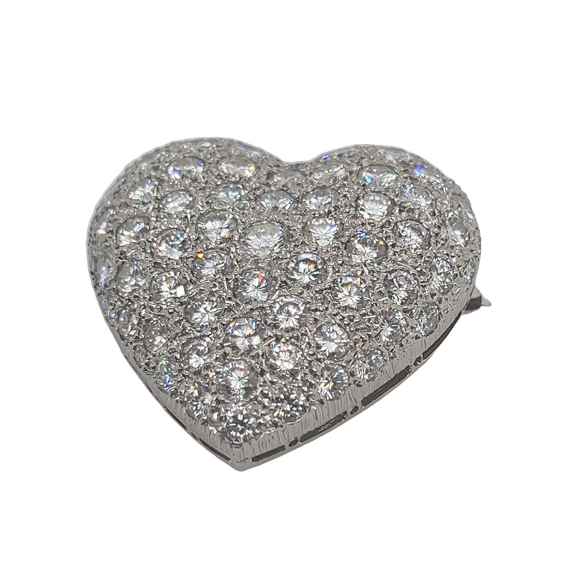 Add a touch of timeless elegance to your ensemble with this exquisite diamond heart brooch. Crafted in 18k gold, this stunning piece dates back to the glamorous 1960s and features 5cts of brilliant cut diamonds that sparkle with unmatched