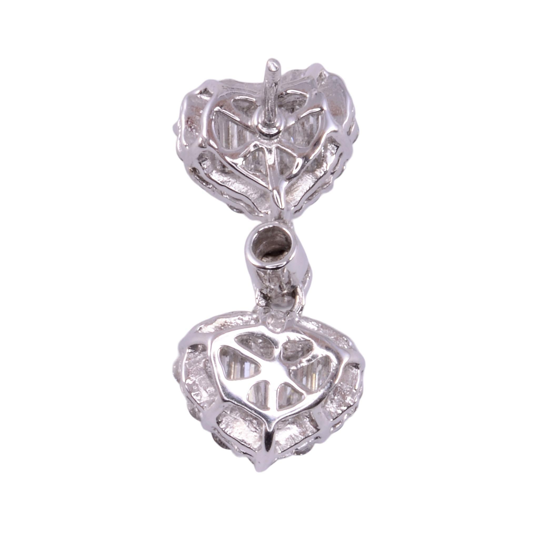 Estate diamond heart motif earrings. These 14 karat white gold rhodium plated heart motif earrings feature 3.0 carat total weight of diamonds. There are 50 round brilliant diamonds at 1.70 carat total weight, along with 16 straight baguettes at 1.30