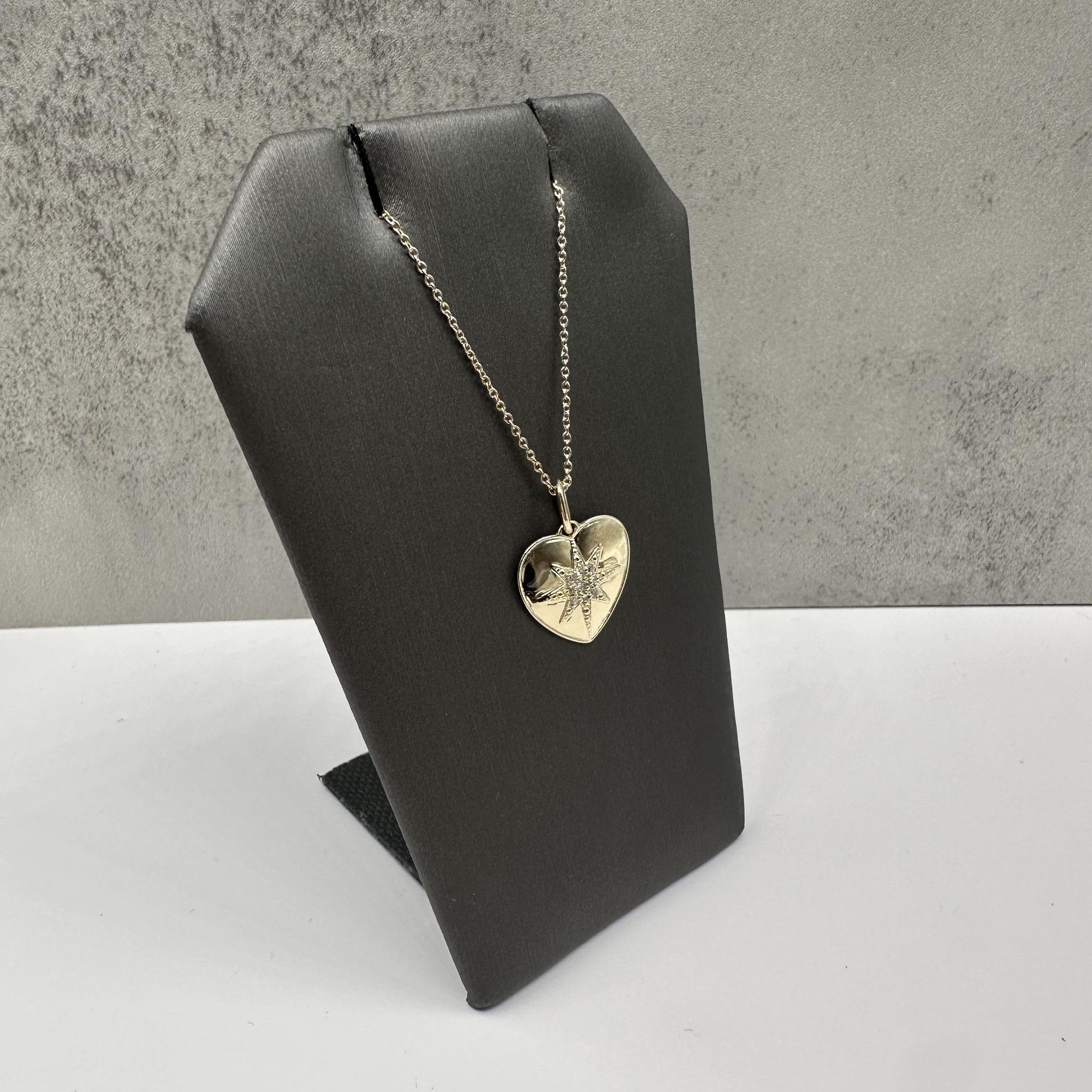 Ce charmant collier cœur en or jaune 10kt est orné de diamants ronds HI SI2-I1 d'un poids total de 0,07 carats, ajoutant une touche d'éclat à son design intemporel en forme de cœur. Fabriqué en or jaune chaud, la chaîne réglable de 15 à 17 pouces