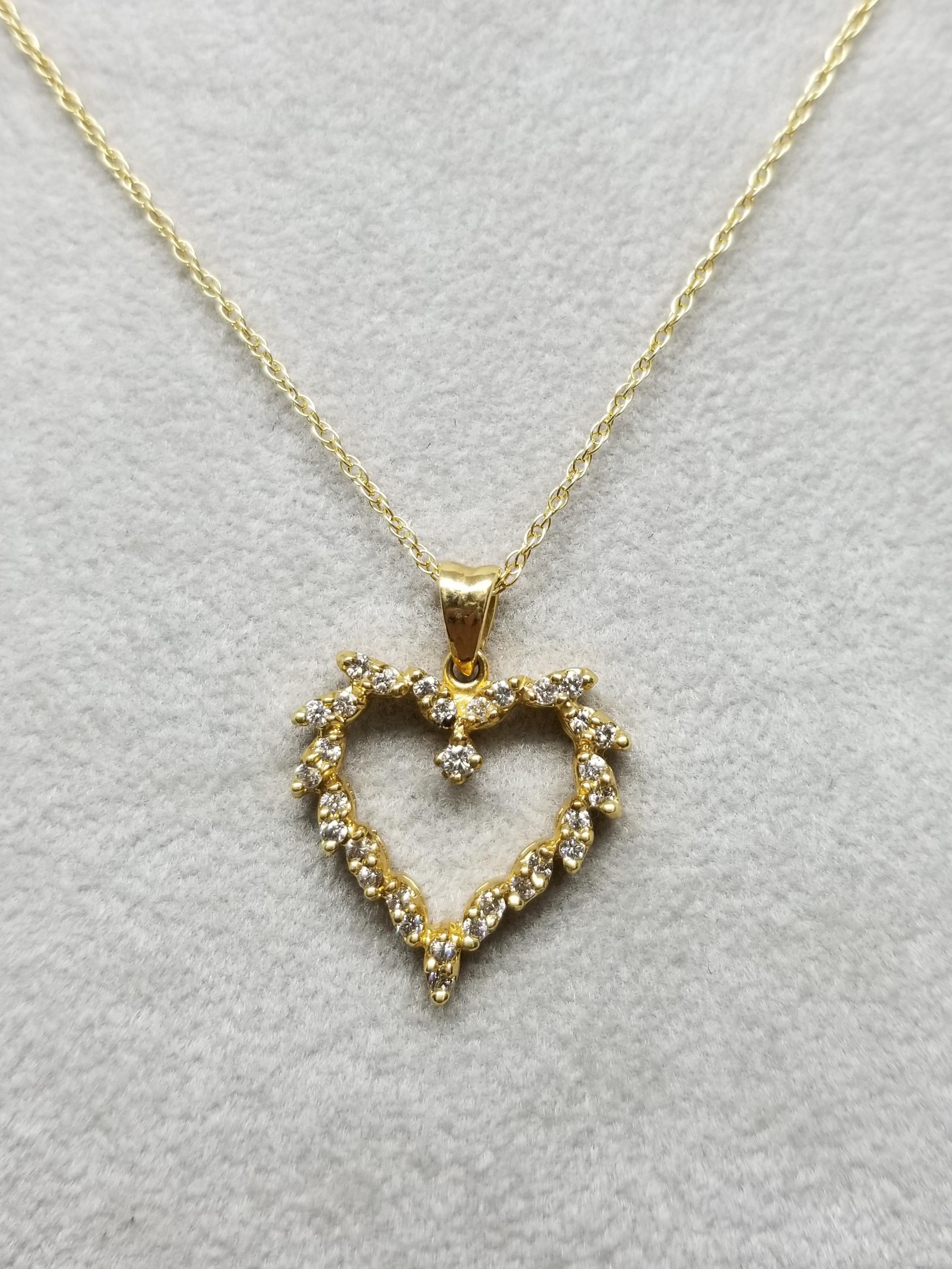 14k yellow gold diamond heart pendant set with 2 rounds in a marquise setting, containing 31 round full cut diamonds of very fine quality weighing .55pts. on a 16 inch chain.