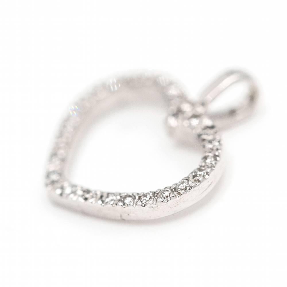 Ciondolo con diamante HEART per donna  Diamanti in taglio brillante con un peso totale di 0,22ct in qualità G/VS  0,75 grammi  Misure: 1,3 cm di lunghezza, compreso l'anello, e 1,2 cm di larghezza.  Oro bianco 18 kt.  Nuovo di zecca  Rif.: D363119CG