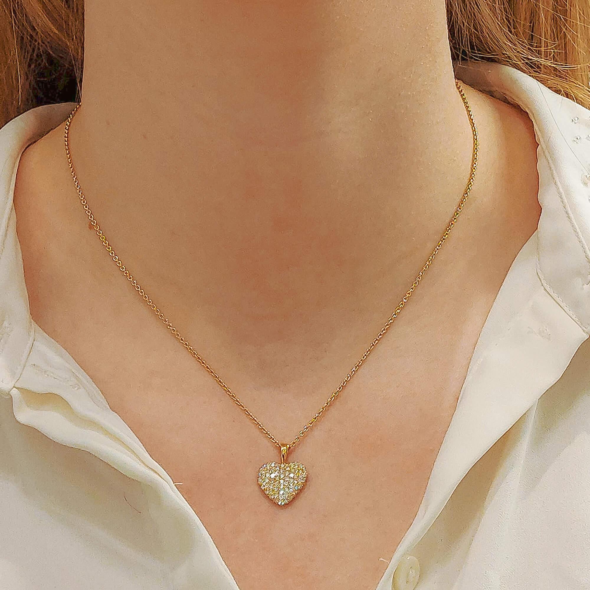 A diamond heart pendant set in 18k yellow gold. 

The pendant is designed in a classic heart motif and is pave-set throughout with round brilliant cut diamonds. The diamonds set within the heart are set in a fancy openwork gallery with heart shaped