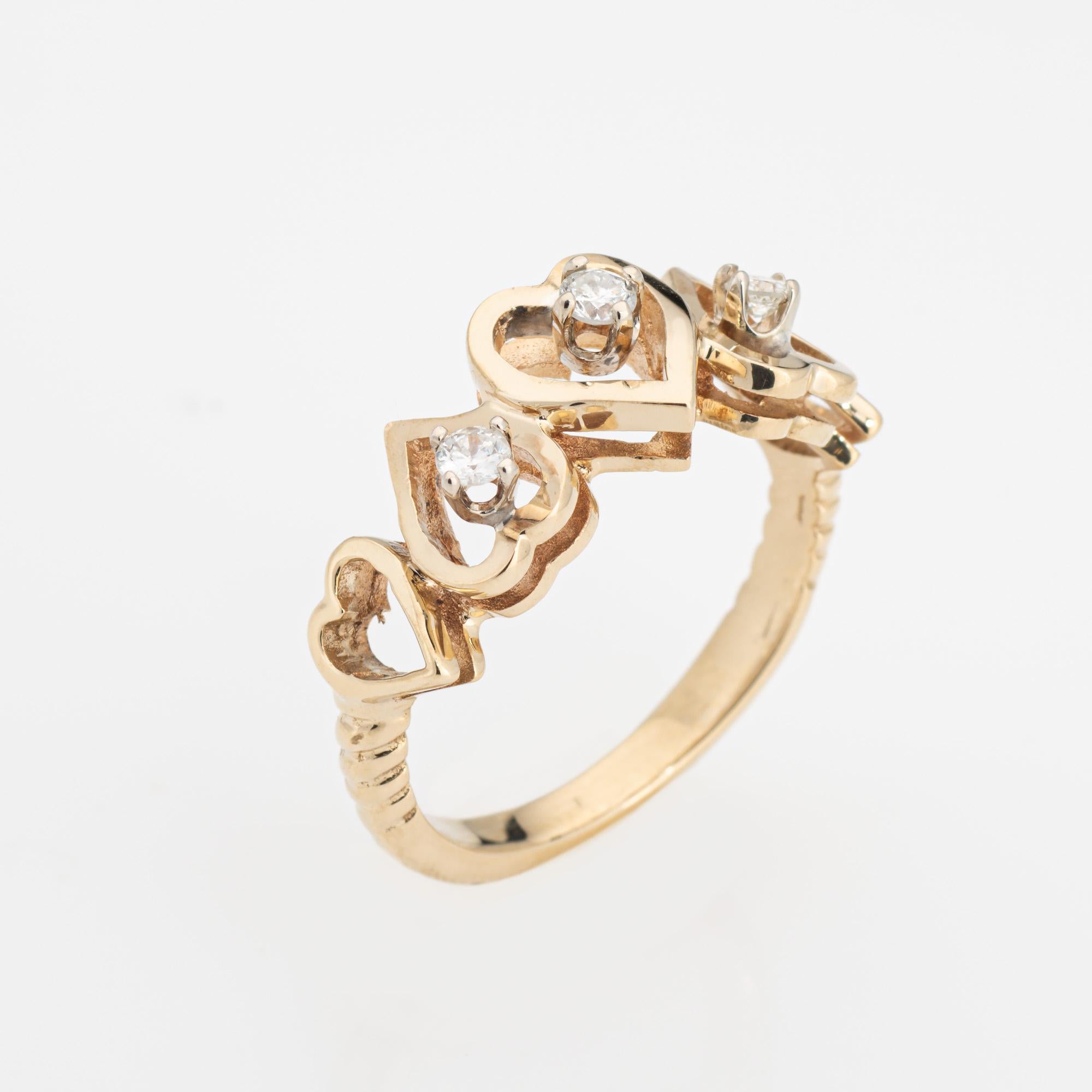 Stylish diamond heart ring crafted in 14 karat yellow gold (circa 1970s to 1980s). 

Three diamonds total an estimated 0.12 carats (estimated at I-J color and SI1-I1 clarity).  

The sweet band features alternating hearts with diamonds perched on