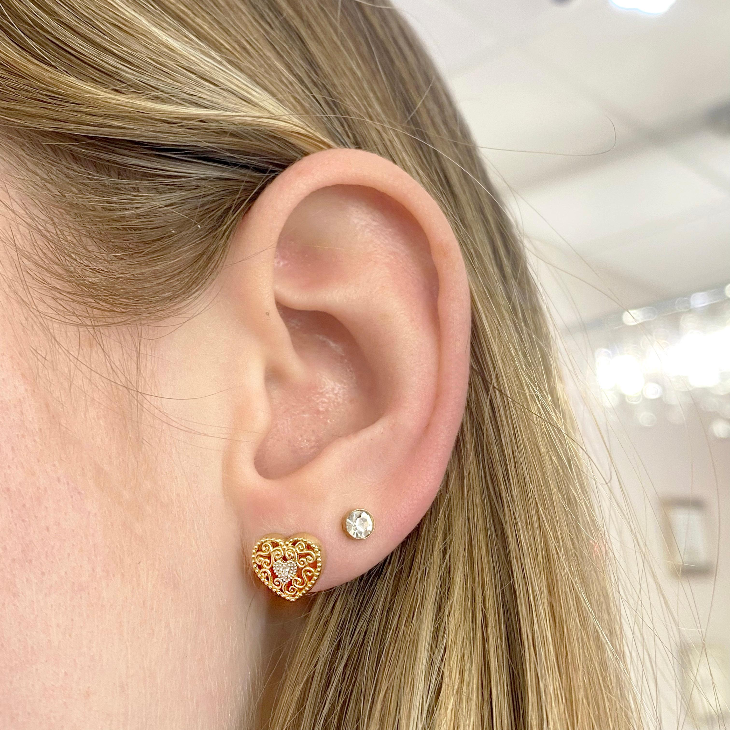 These stunning heart shaped earrings provide a look that is both trendy and classic. Each stud has a single diamond and intricate filigree which makes these earrings so special. This set is a great staple to add to your collection, and can be worn
