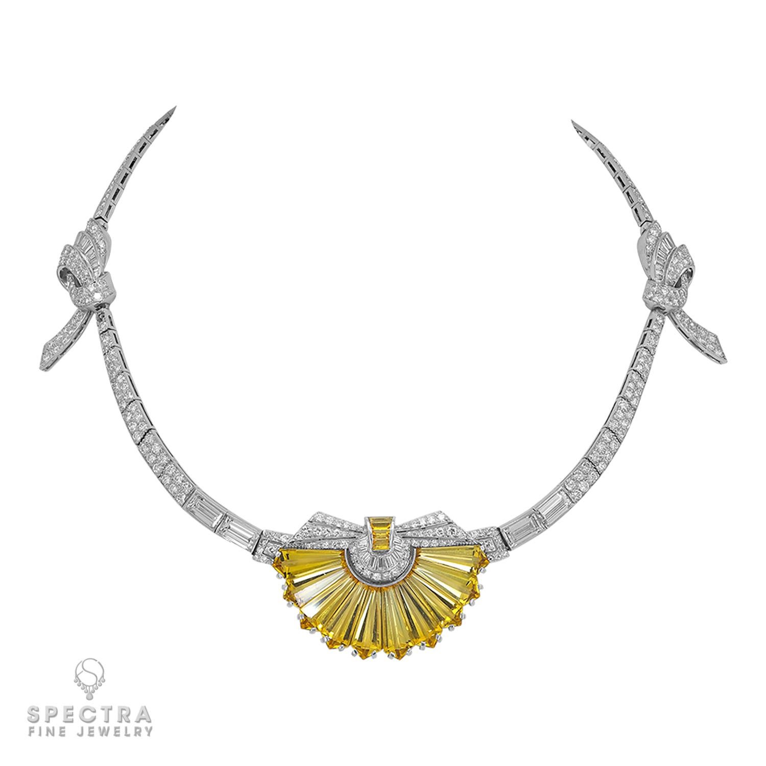 A stunning and unique necklace set at the front with a fan of elongated hexagonal-shaped yellow heliodors (beryl), with circular and baguette-cut diamond accents at the top, extending on either side to two rectangular-cut diamonds and the