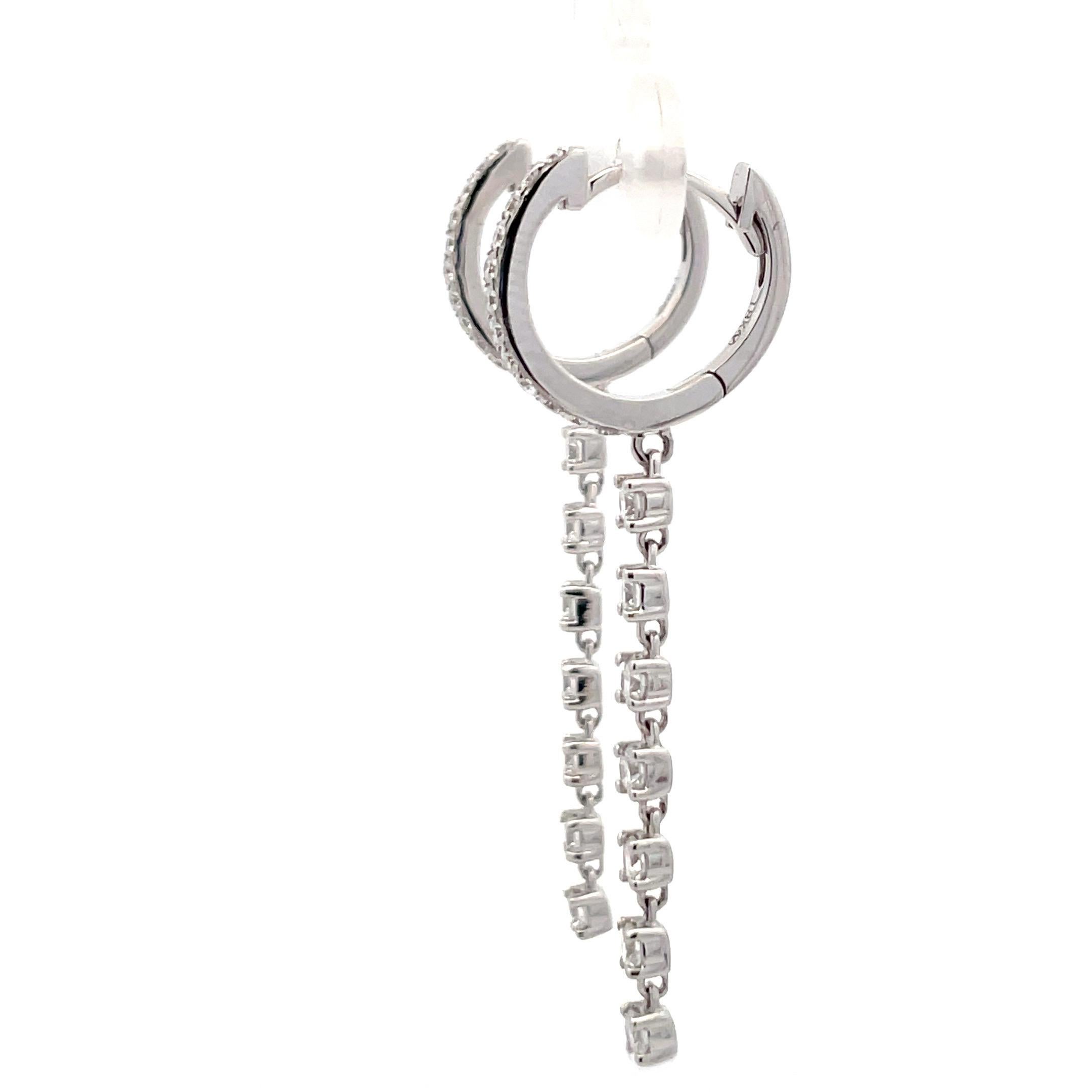 18 Karat White gold drop earrings featuring a hoop motif with 24 round brilliants weighing 0.30 carats with a diamond dangle drop of 14 diamonds, 0.63 carats.