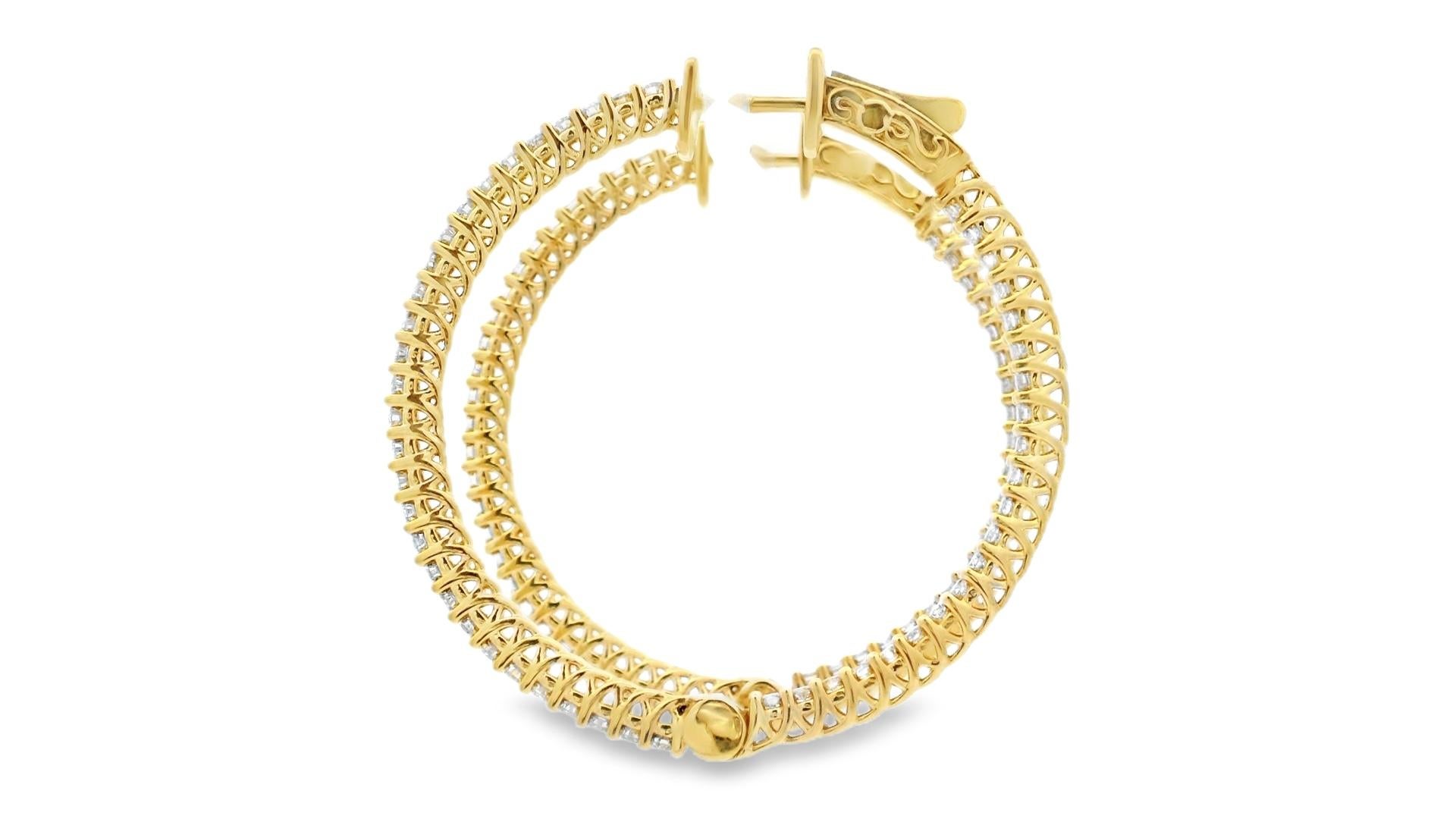 These luxurious diamond hoop earrings are crafted in warm 14K yellow gold and set with 100 round brilliant-cut diamonds totaling 2.00 carats. Designed to offer full-circle brilliance, the diamonds are channel-set along both the inner and outer