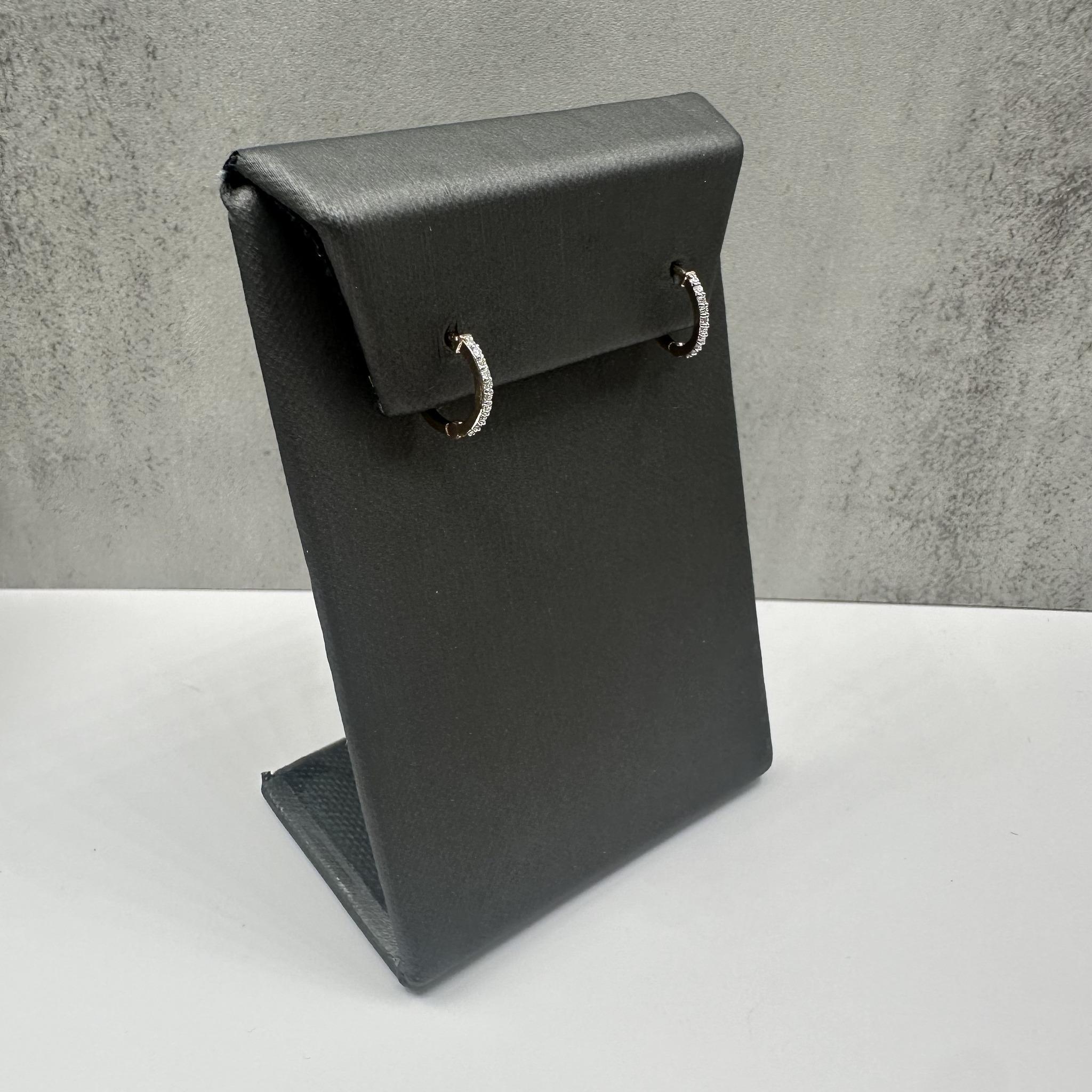 Questi eleganti orecchini huggie con diamanti in oro giallo 14 carati presentano 0,10 carati di diamanti tondi naturali GH SI, che offrono uno scintillio sottile ma sofisticato. Il diametro esterno di 11,4 mm è perfetto per essere indossato tutti i