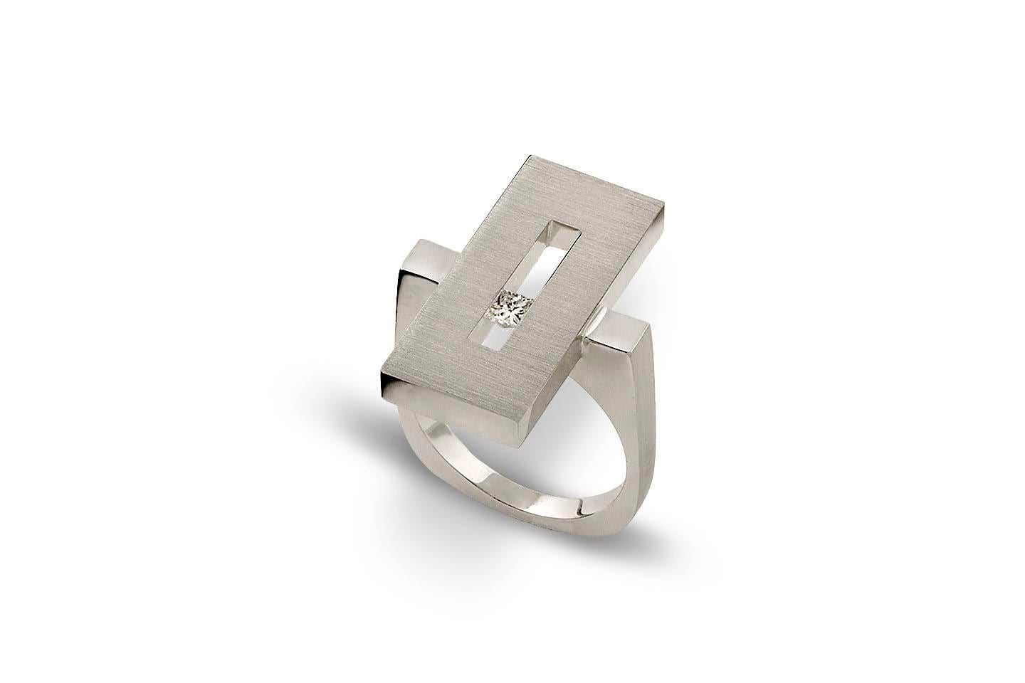 This modern Diamond in White Gold Suspended Rectangle Ring is part of our Suspension Collection, an architectural element transformed into a ring. The cantilever seems to teeter on a slim square shank. Shown here in white gold set off center with an