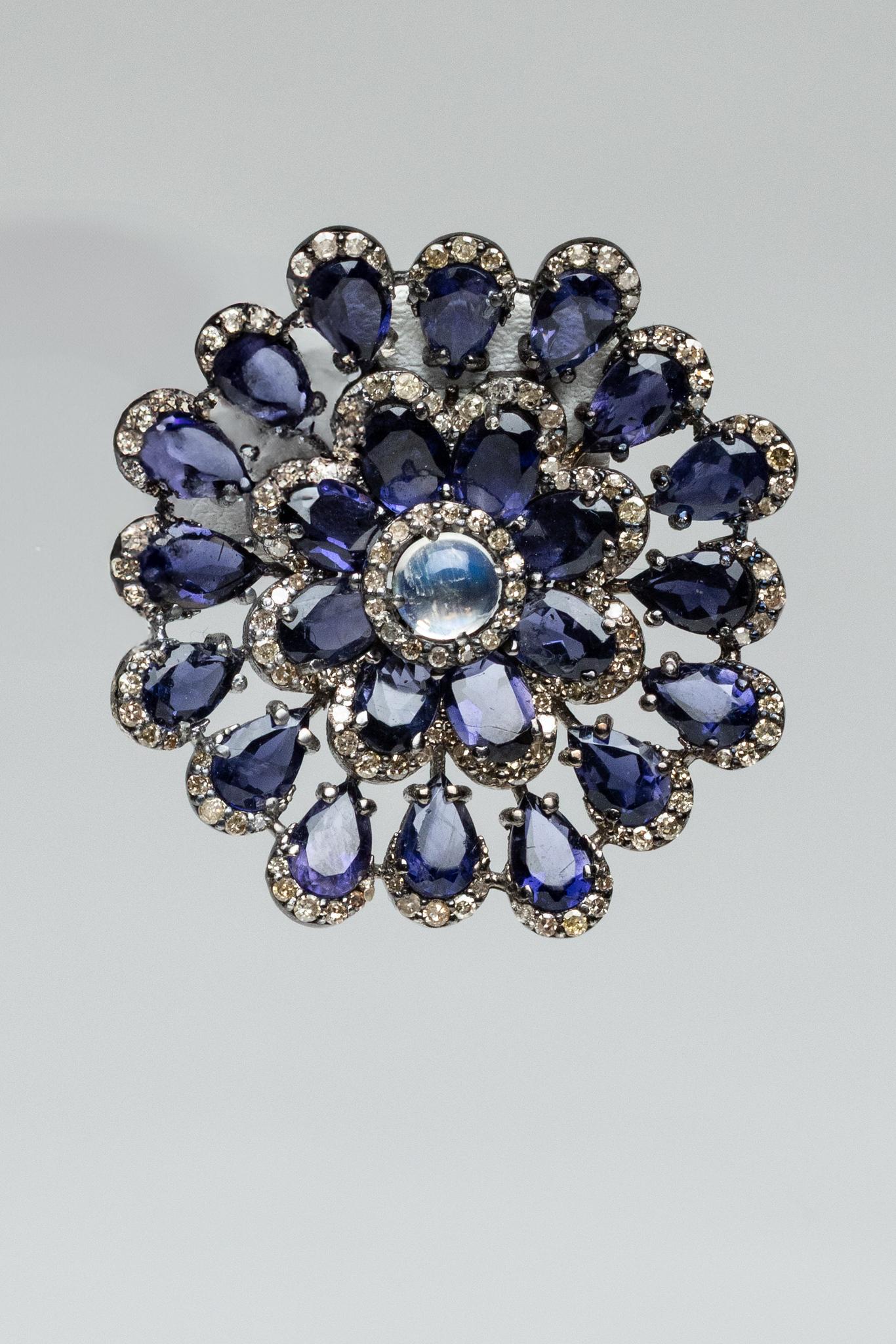 Un paio di splendidi orecchini a perno con motivo floreale, composti da gemme di iolite a forma di pera e da una pietra di luna rotonda cabochon al centro, bordata di diamanti.  Le pietre di iolite sono tutte bordate all'estremità da diamanti