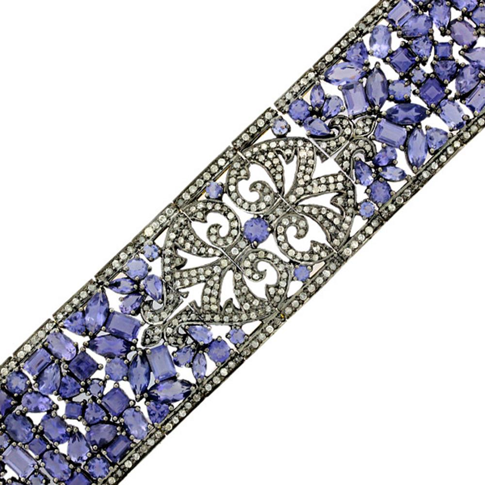 This Diamond Iolite Designer Mosaic Bracelet in Silver and 18K Gold is pretty and wraps around the wrist very nicely. 

18kt gold: 12.42gms
Silver: 54.55gms
Diamond:4.59cts
Iolite:38.13cts
