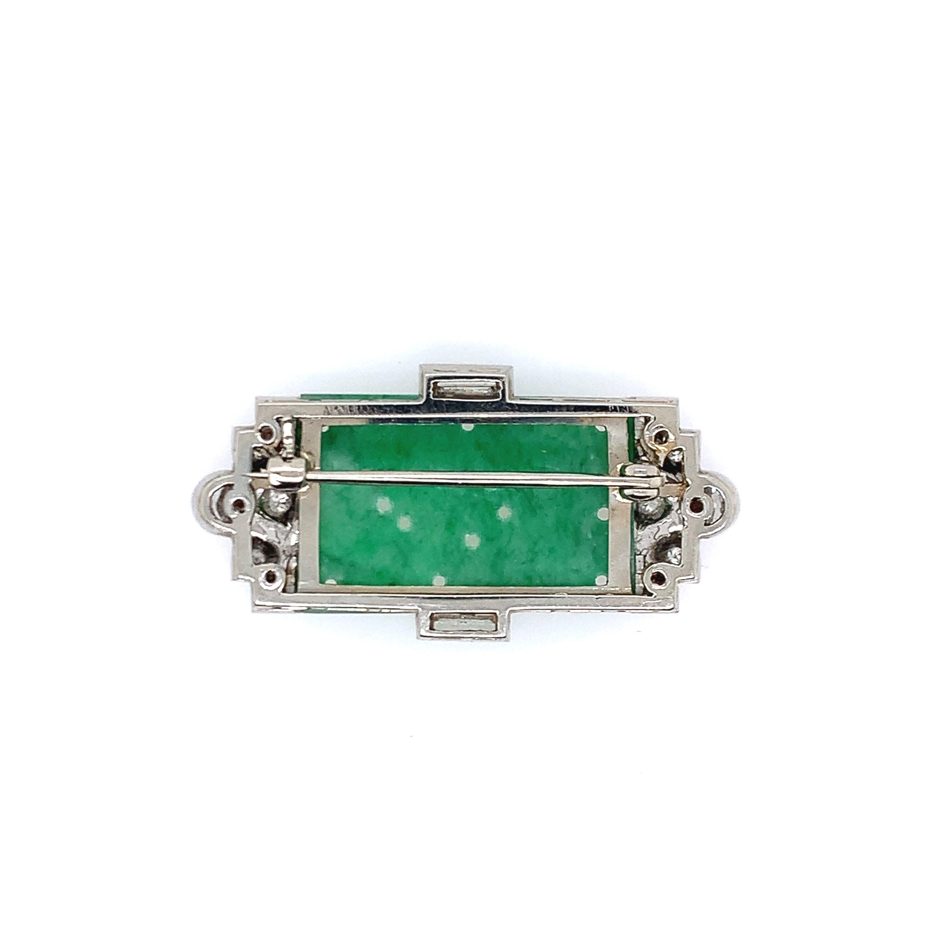Set in platinum, this brooch consists of diamonds totaling 1 carat and natural, type A jade at its center. Created in the 1920s, this art deco brooch's length is 0.75 inch and its width is 1.5 inches. The total weight is 8.9 grams. 