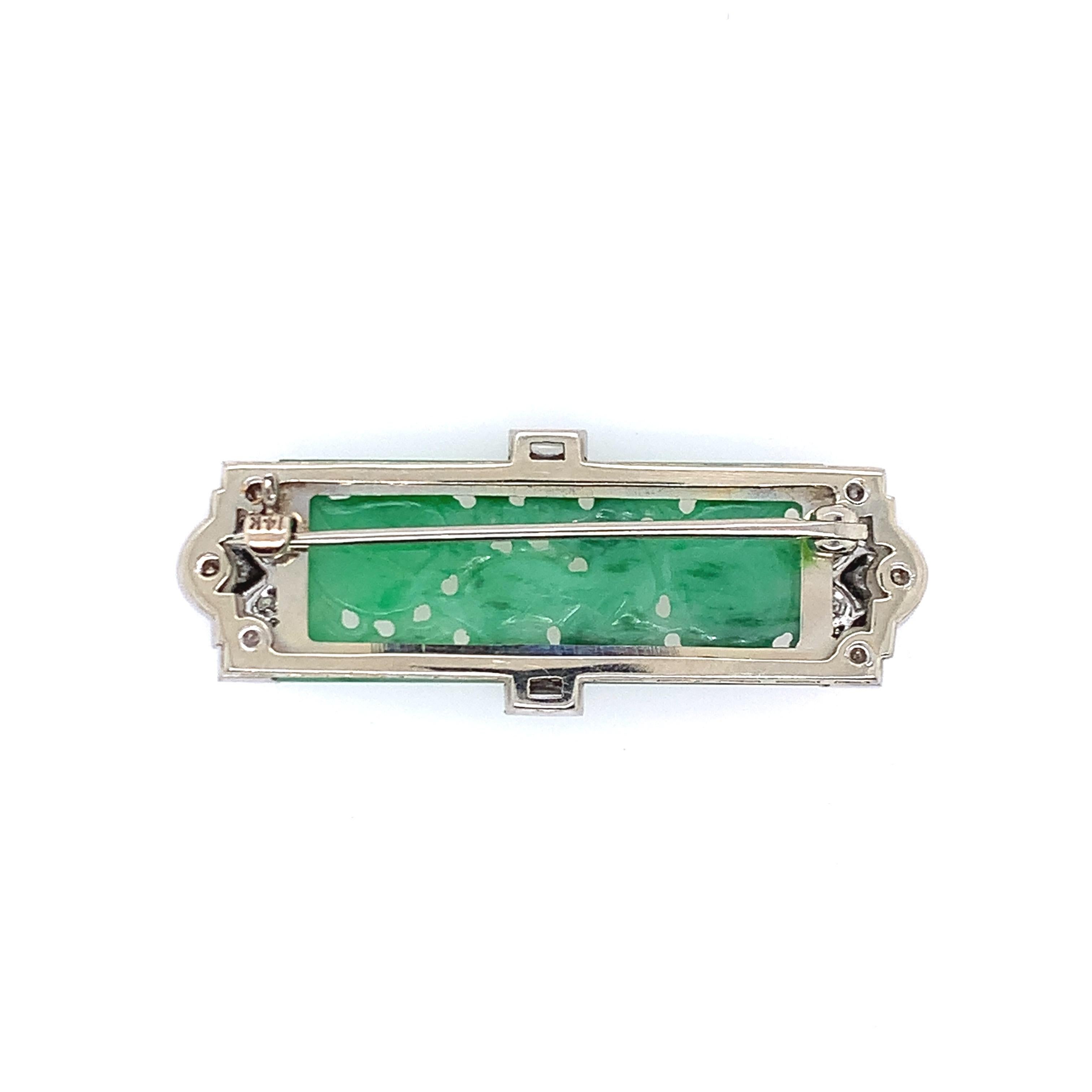Created in the 1920s, this art deco brooch is set in platinum and consists of diamonds totaling 0.50 carat as well as natural, type A jade at its center. The length is 0.63 inch and the width is 1.75 inches. The total weight is 8.3 grams.
