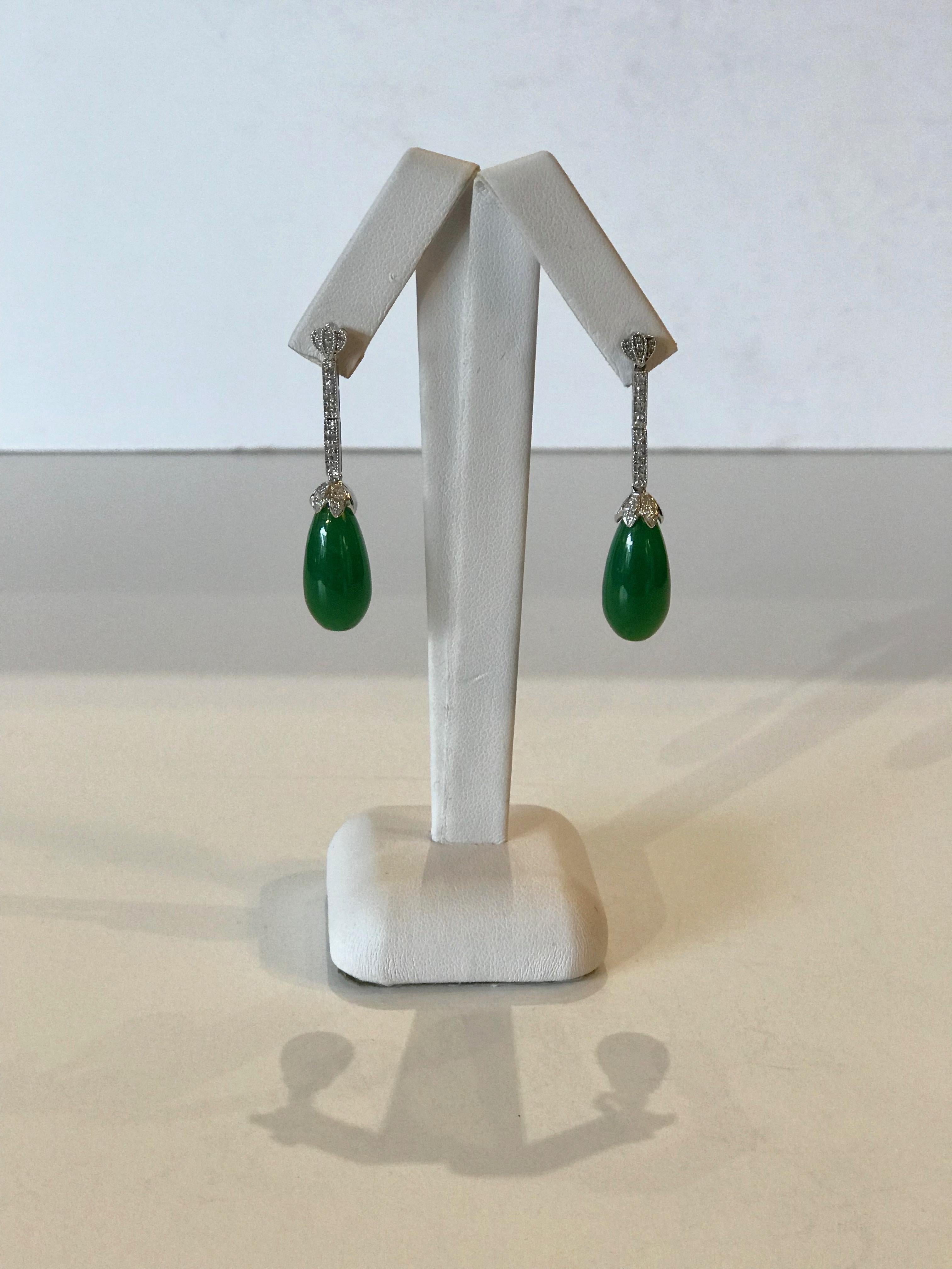 A pair of Gold Diamond and Jadeite drop earrings held by a post, secured by a butterfly clasp. The fan-shaped top mount is set with 6 small round cut diamonds, 12 in total. Vertical galleried settings in white gold are micro set with diamonds, total