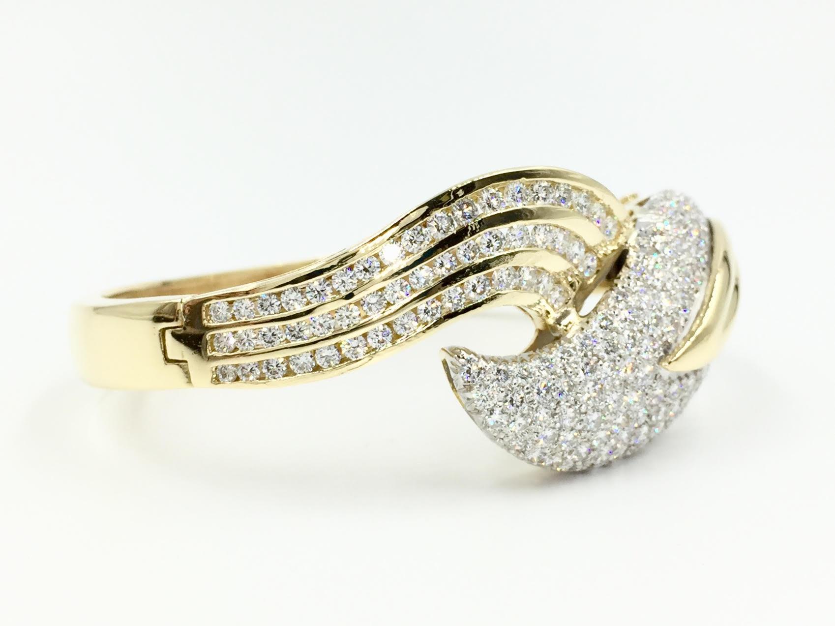 This unique and brilliant leaf design bangle is made with a total of 6.09 carats of high quality diamonds, approximately E-F color, VS1 clarity. Diamonds are expertly pavé set on one side with three rows of channel set diamonds on the other, adding