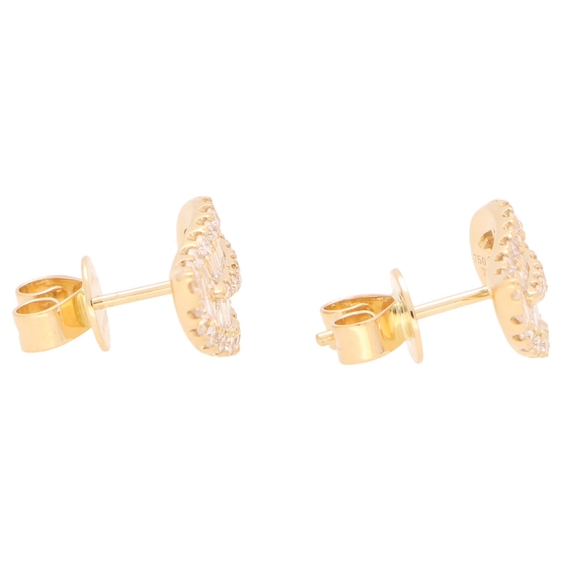 A beautiful pair of diamond leaf earrings set in 18k yellow gold. 

Each earring depicts a simple leaf design and is set with a mixture of round brilliant cut and baguette cut diamonds. The contrast between the two cuts of diamond is superb and