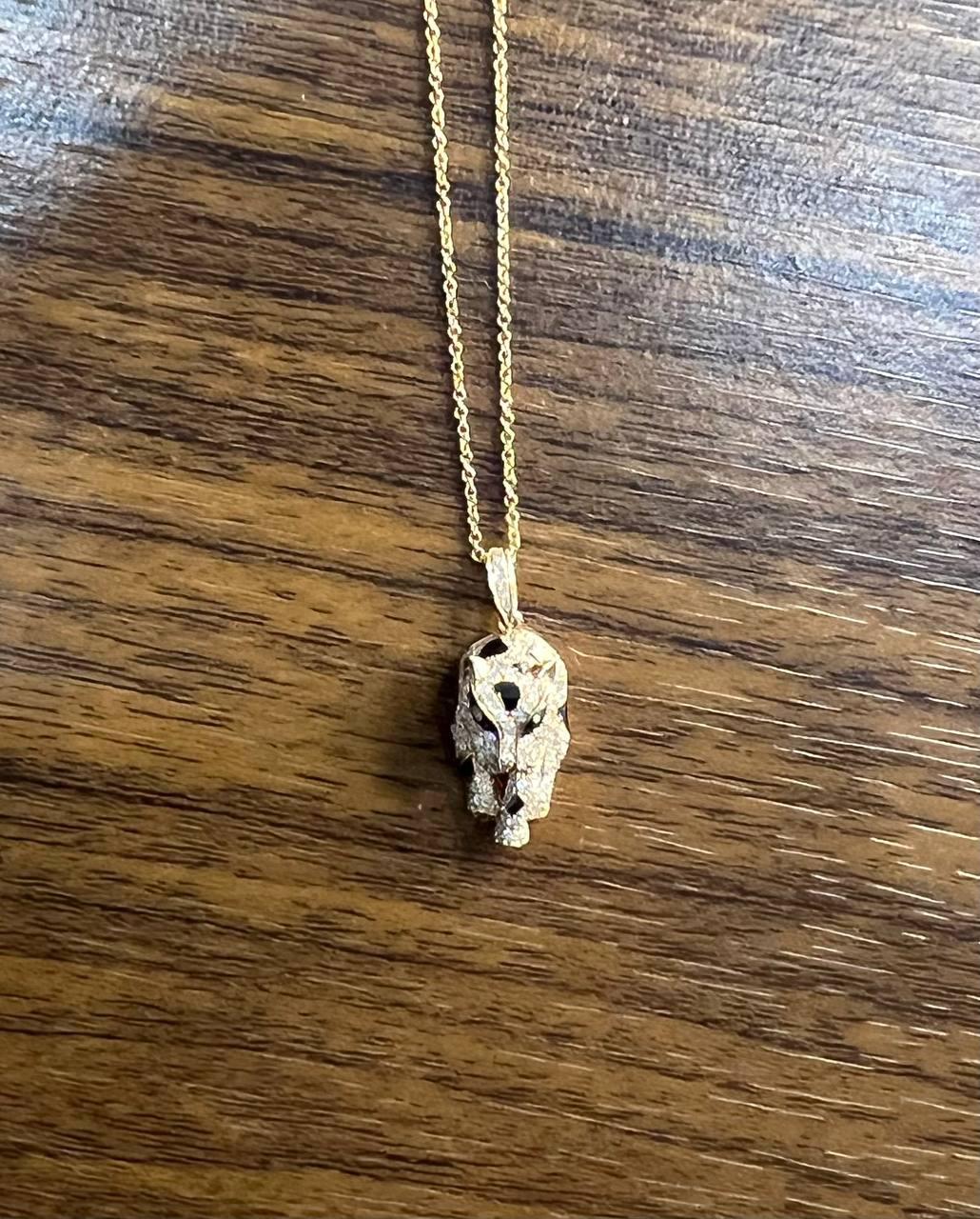 Explore the striking allure of this Pendant Necklace. The necklace features a gold chain with a detailed leopard head pendant. The pendant is adorned with intricate textures and black spots, capturing the essence of a leopard in motion. The design