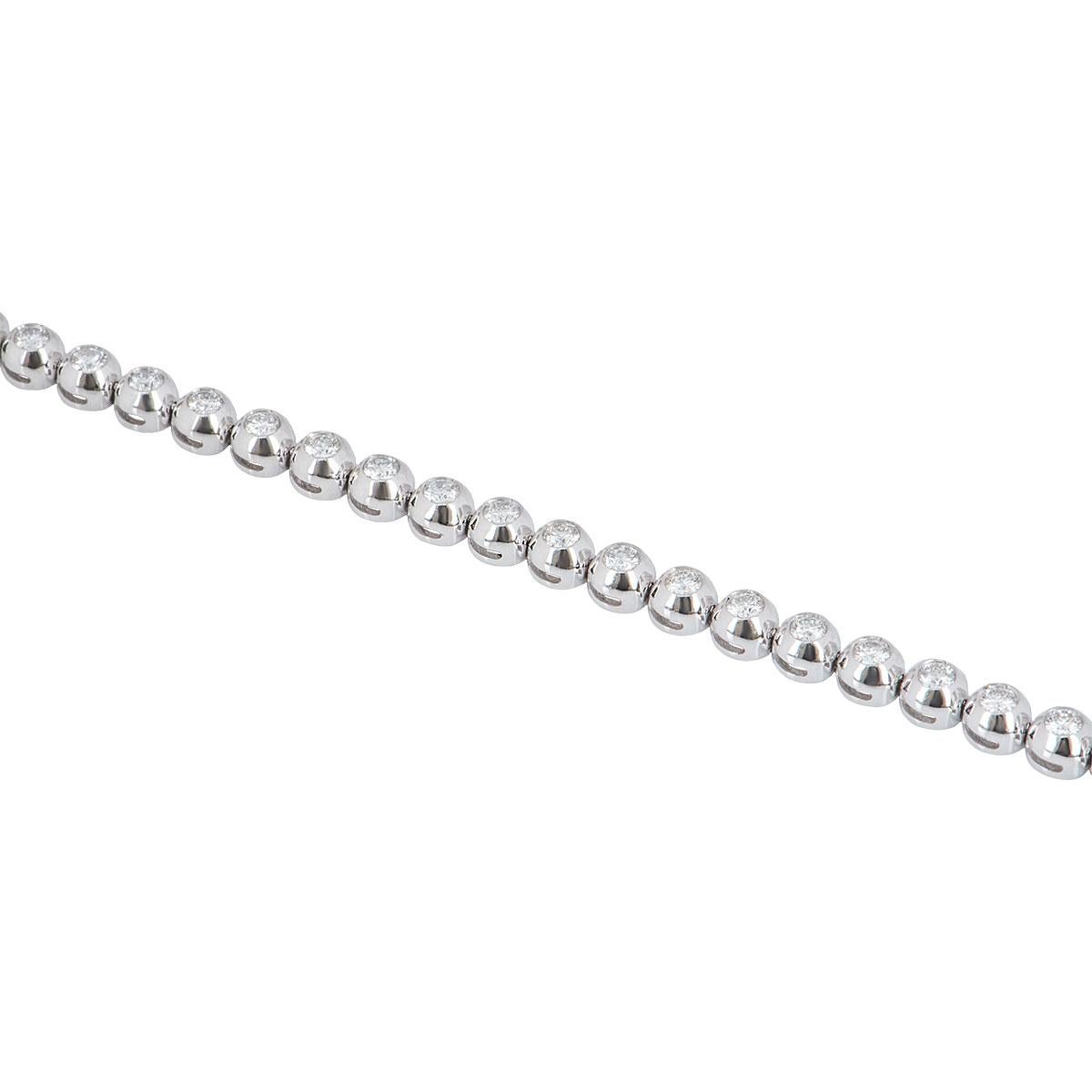 A stunning 18k white gold diamond line bracelet. The bracelet comprises of 34 round brilliant cut diamonds in a bezel setting with a total weight of 2.74ct, G-H colour and VS+ clarity. The bracelet features a box clasp with a figure of 8 clasp on