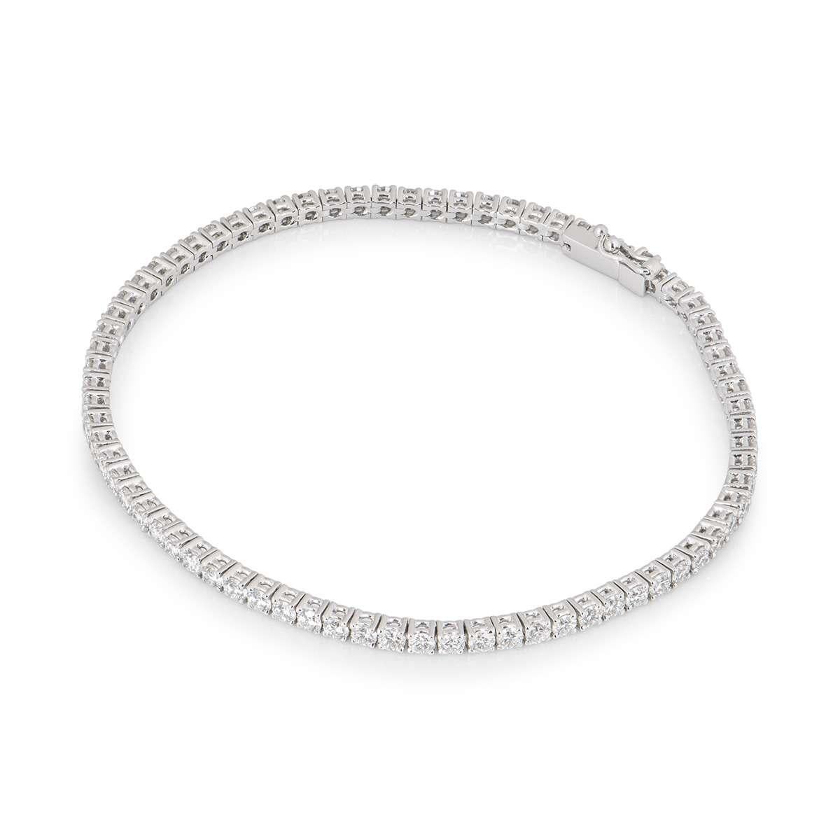 An 18k white gold diamond line bracelet. The bracelet is set with a total of 3.50ct of round brilliant cut diamonds in a claw setting. The bracelet measures 7 inches in length and features a tongue clasp, with a figure of eight clasp on the side for