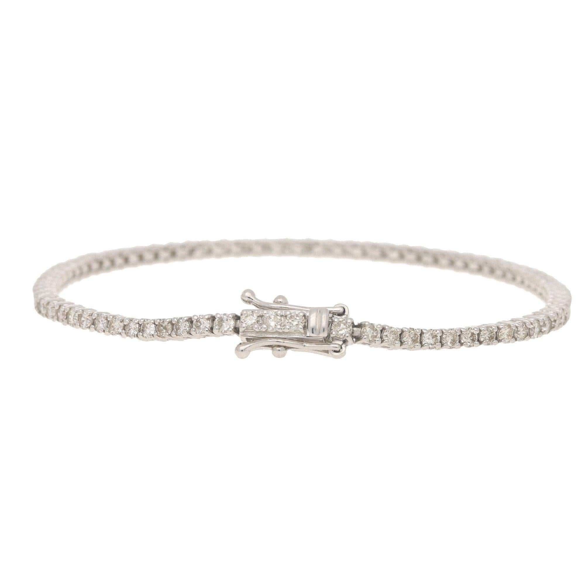 A classic diamond line bracelet set in 18k white gold. 

The bracelet is composed of exactly 77 round brilliant cut diamonds which are all seamlessly set in articulated claw settings. This particular design is a firm favourite as it can be worn for