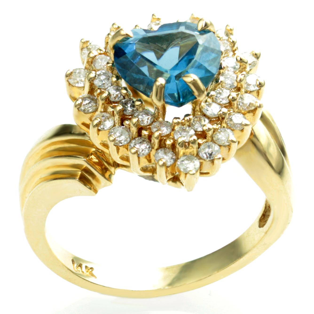 This fabulous circa 1980s ring is made in 14k yellow gold and prong-set with a faceted 8.0mm x 8.0mm London Blue heat-treated topaz heart surrounded by two rows of sparkling round diamonds. A romantic and elegant design. Measurements: 0.59