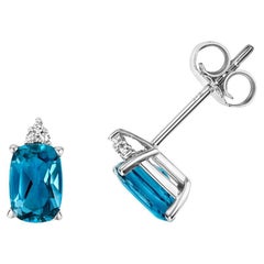 DIAMOND 
LONDON BLUE TOPAZ OVAL CLAW SET STUDS IN 9CT WHITE Gold