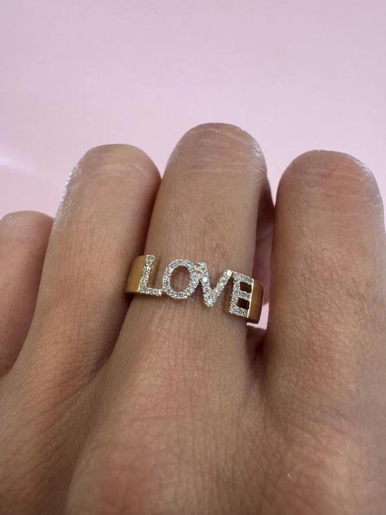 14 Karat yellow gold statement ring featuring a written diamond LOVE word on a 5.4 mm gold band. 

More Written Rings Available
Message for Pictures & Details
Search Harbor Diamonds