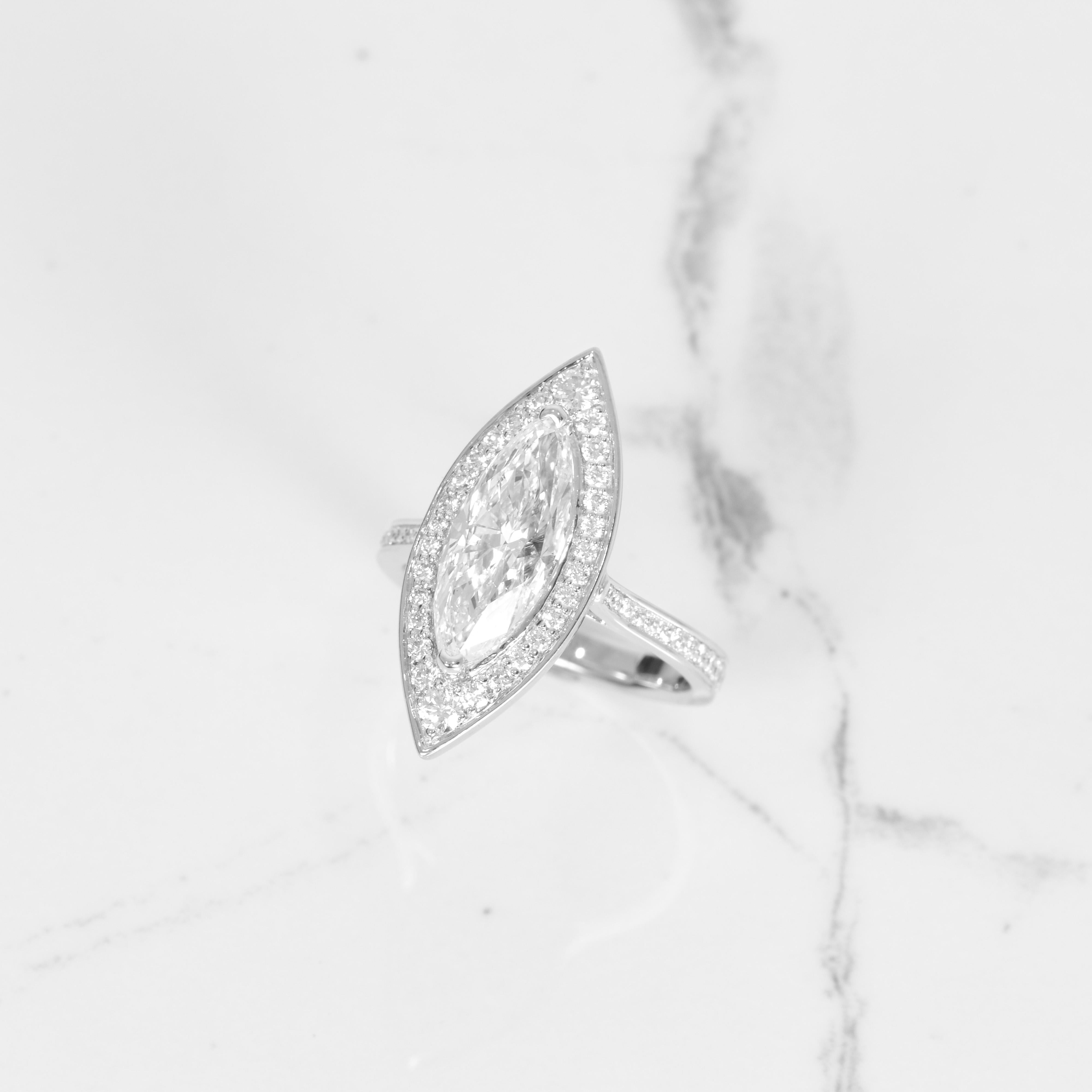 This ring is quite the showstopper! The center diamond is a gorgeous GIA certified 3.03ct marquise diamond that is G in color with SI2 clarity. Surrounding the stunning stone is .55 carats of diamonds, all beautifully set in 14k white gold. The top