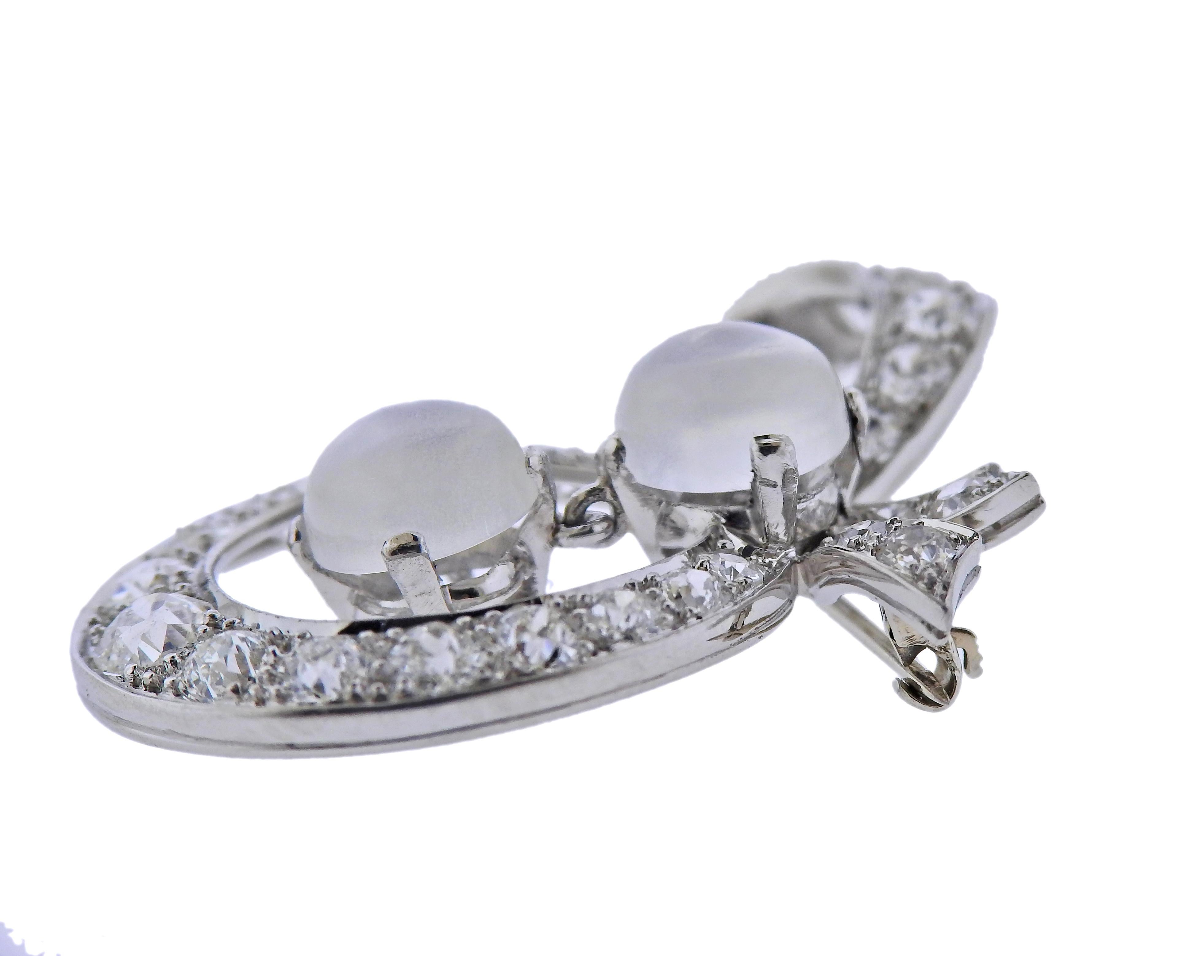 14k gold bow brooch set with two 7mm moonstones, and approx. 1.60ctw in diamonds. Brooch measures 32mm x 21mm. Marked 14k. Weight - 7.6 grams.