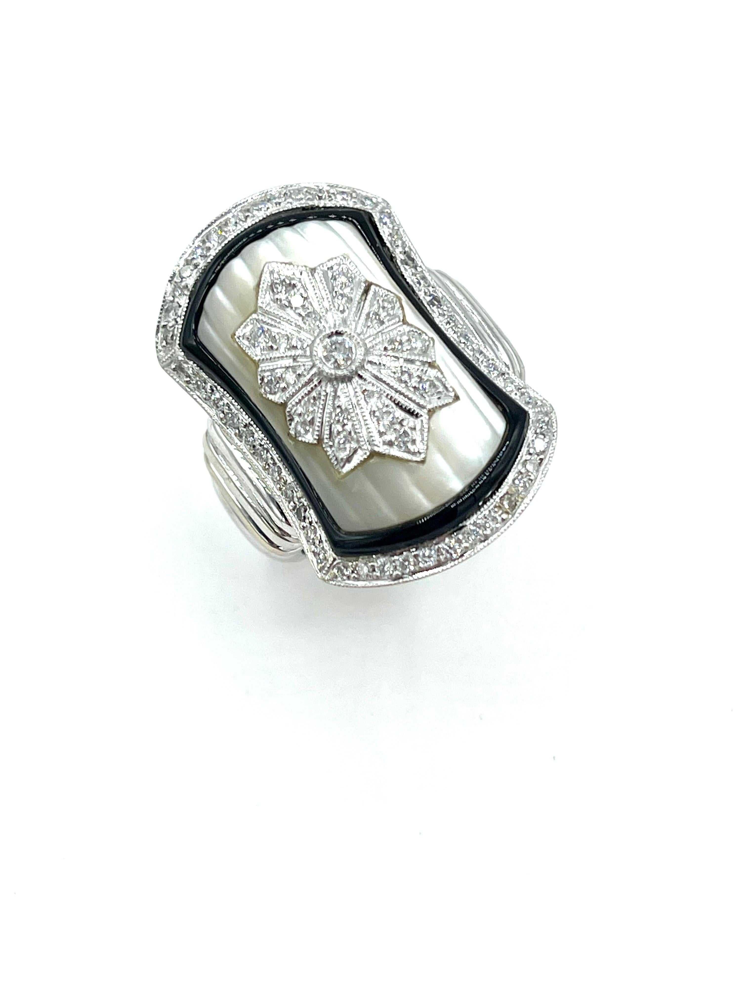  An amazing ring in every aspect.  The ring is designed with a filigree Diamond center set in carved Mother of Pearl, and framed in a single row of Onyx and Diamonds.  The ring is made in 18K white gold.  There is a total of 0.52 carats in round