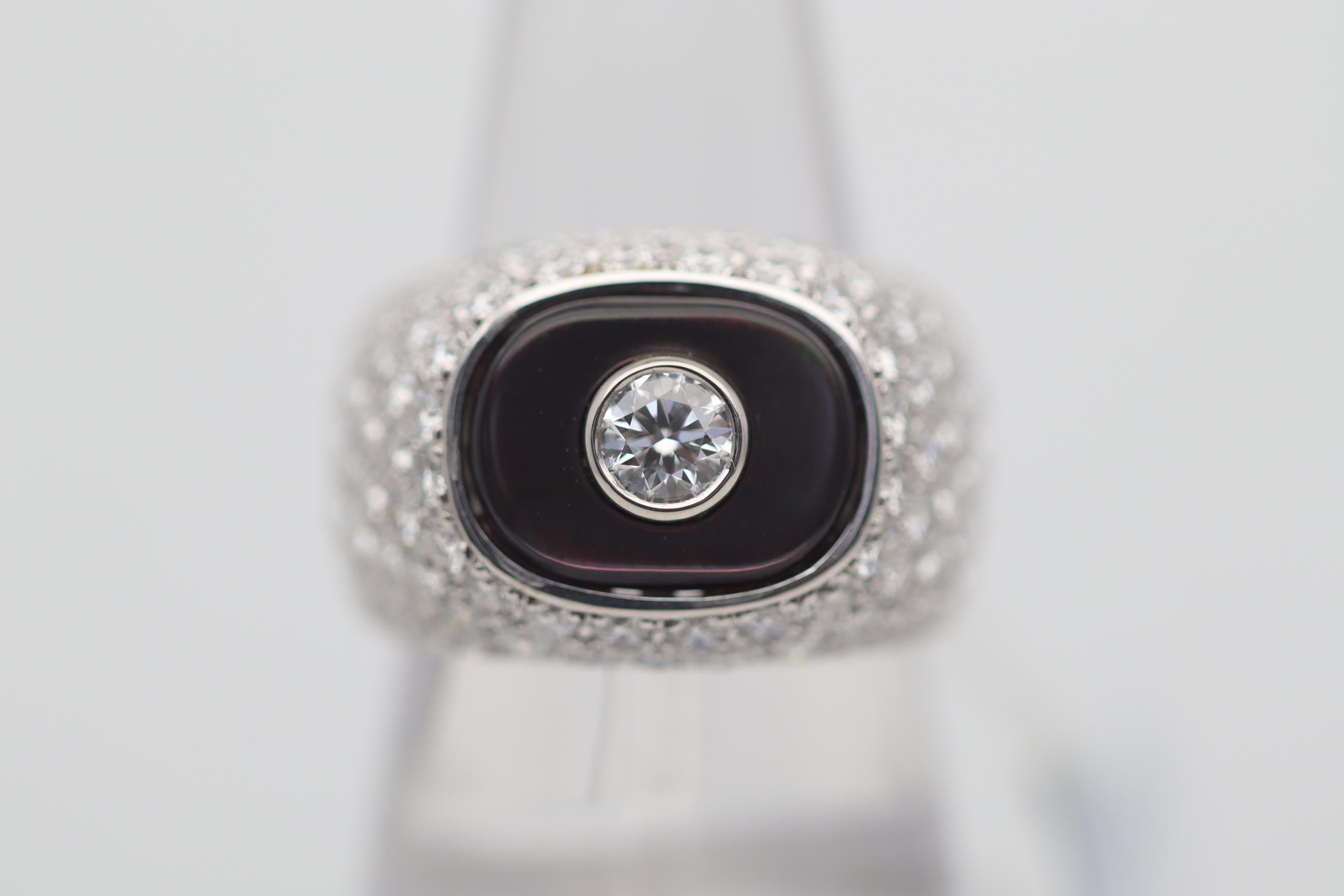 A lovely and substantial ring featuring diamonds and mother-of-pearl. The central diamond weighs 0.42 carats on its own, large and clean, while the side diamonds weigh a total of 3.77 carats. A fine piece of Tahitian mother-of-pearl with beautiful