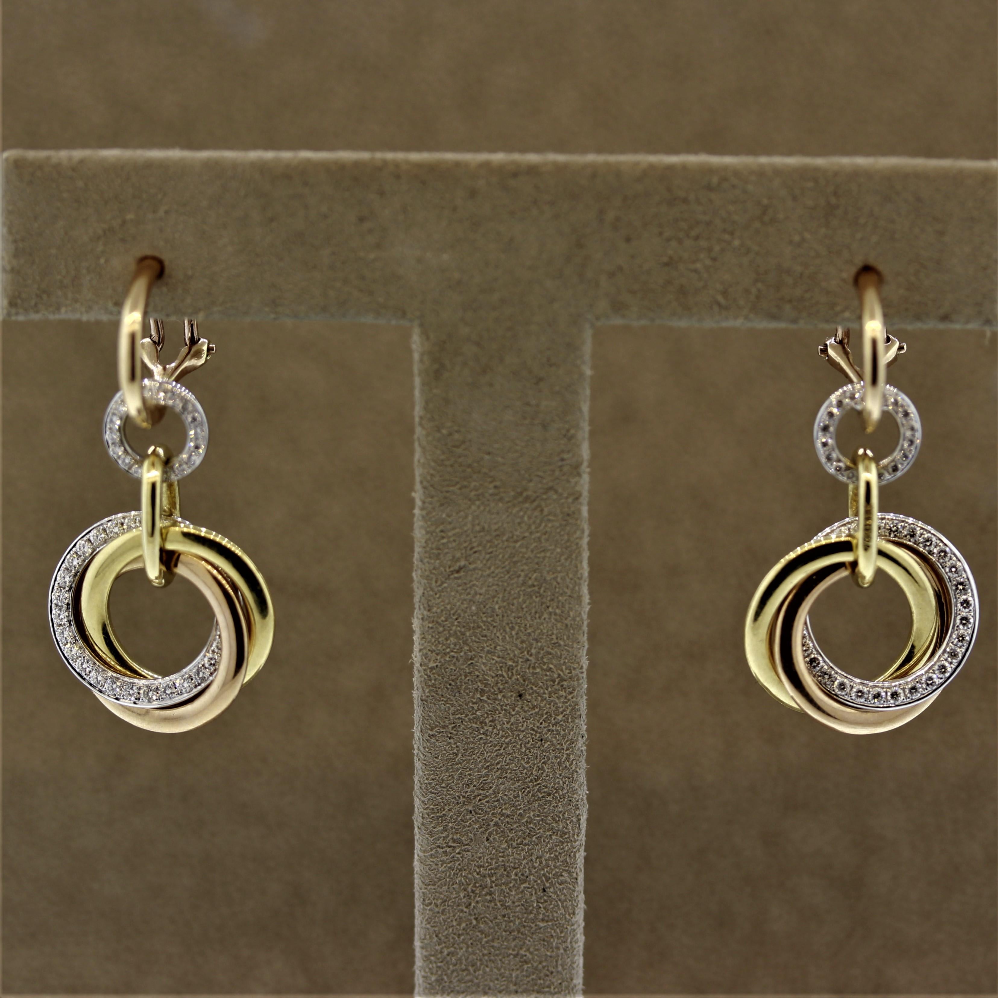 Ein einzigartiges und stilvolles Paar Ohrringe. Sie sind aus 18-karätigem Gold gefertigt und verfügen über 3 unabhängige Goldreifen aus Weiß-, Gelb- und Roségold, die miteinander verzahnt sind. Die Reifchen aus Weißgold sind mit runden Diamanten im
