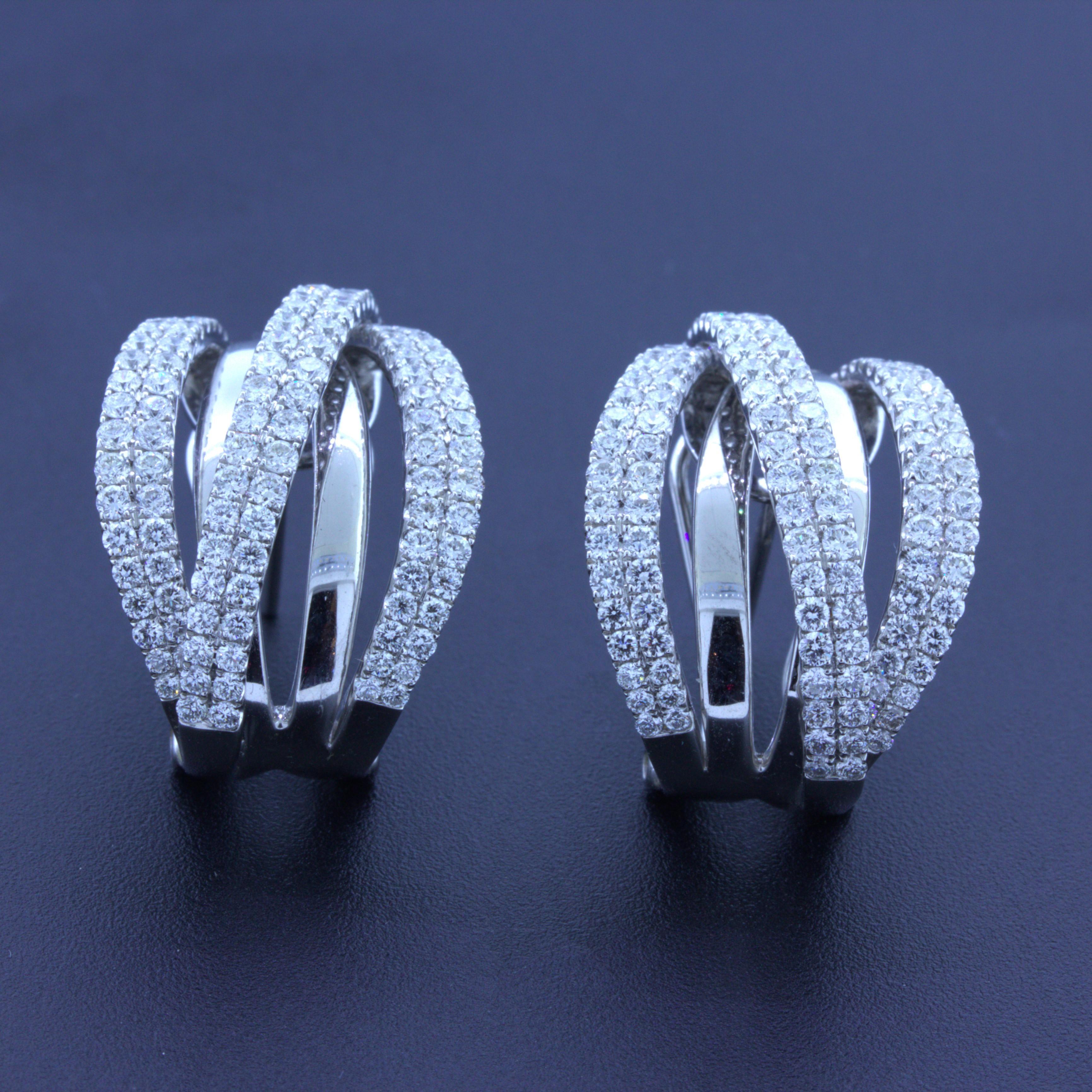 A modern take on the classic huggie, these earrings feature 3.24 carats of round brilliant-cut diamonds set in overlapping rows giving the piece a 3-dimensional look. Made in 18k white gold, these huggies are stylish and feature very fine VS F-G