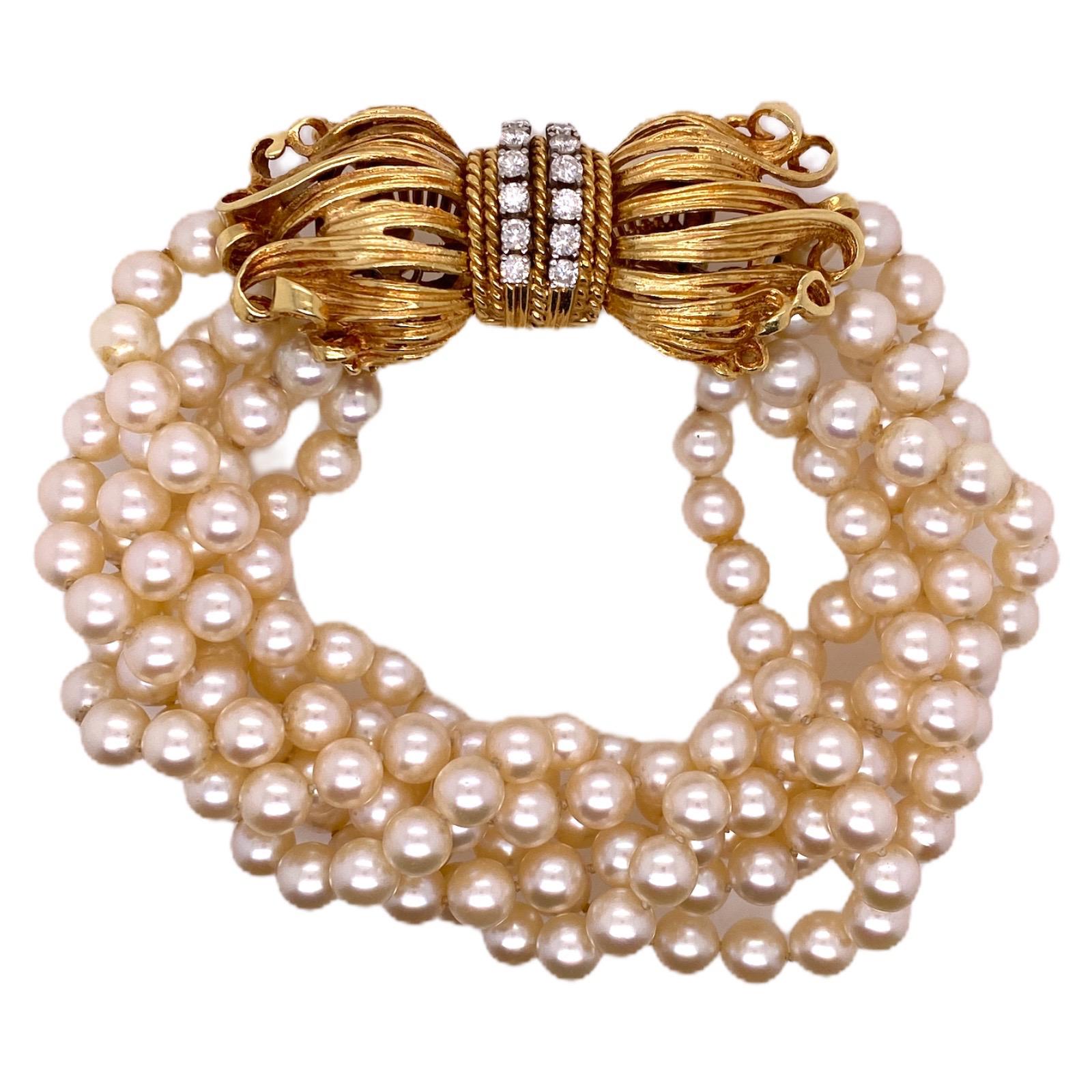 Stunning cultured pearl bracelet crafted with a diamond and 18 karat yellow gold bow shape clasp. The 6 strands of beautifully matched pearls measure 5.5-6.0 mm each, and the clasp features 14 round brilliant cut diamonds weighing 1.00 carat total