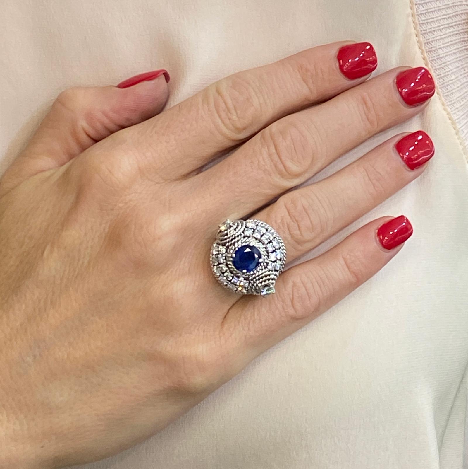 Stunning contemporary diamond sapphire round cocktail ring. This statement ring features a center 2.00-carat blue sapphire surrounded by 2.00-carats round briliant cut diamonds.  The diamonds are all H-I color and VS2-SI2 clarity. The dome shaped