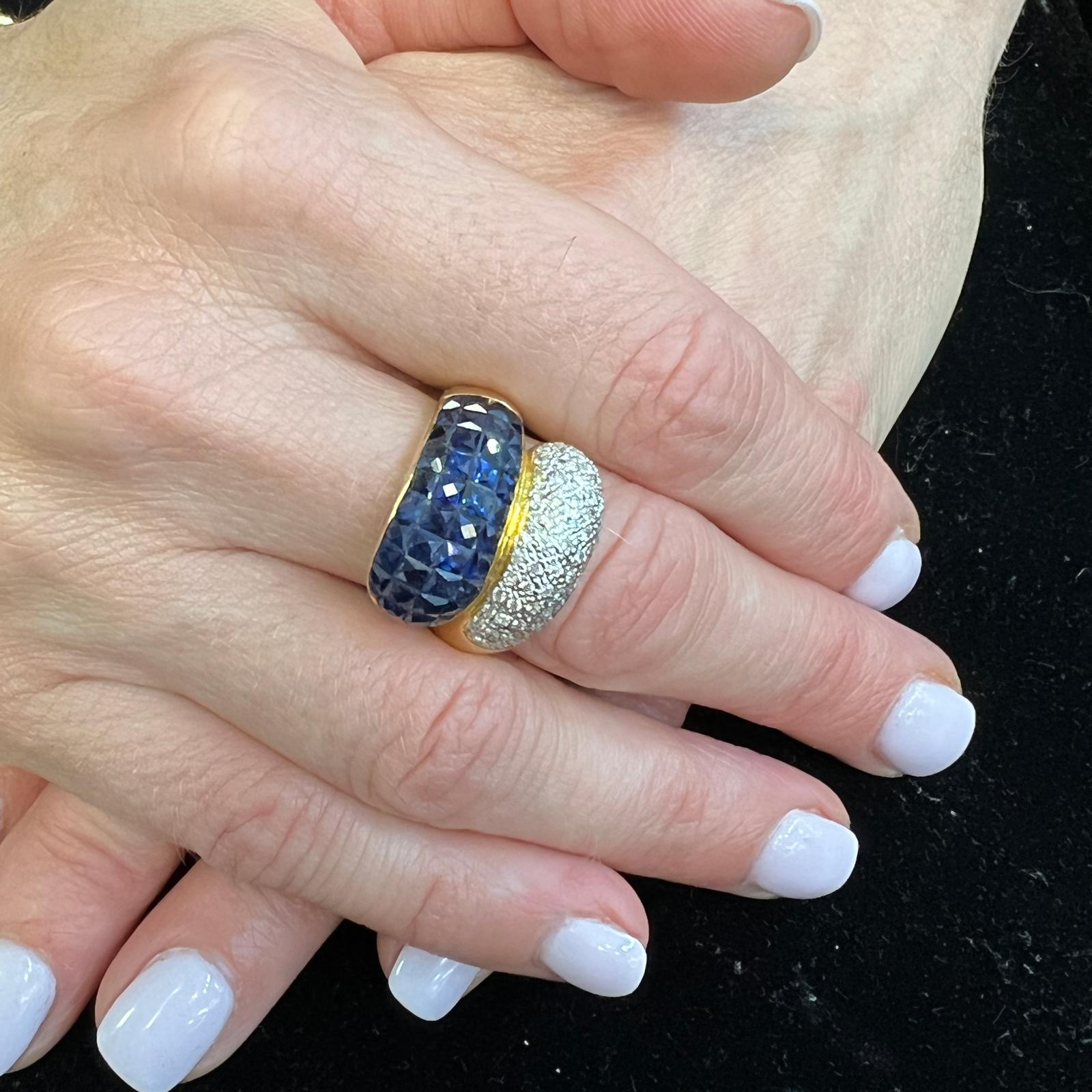 Diamond and sapphire bypass ring crafted in 18 karat yellow gold. The ring features round brilliant cut diamonds weighing approximately .64 carat total weight and graded H-I color and SI clarity. The 38 French cut natural blue sapphires weigh