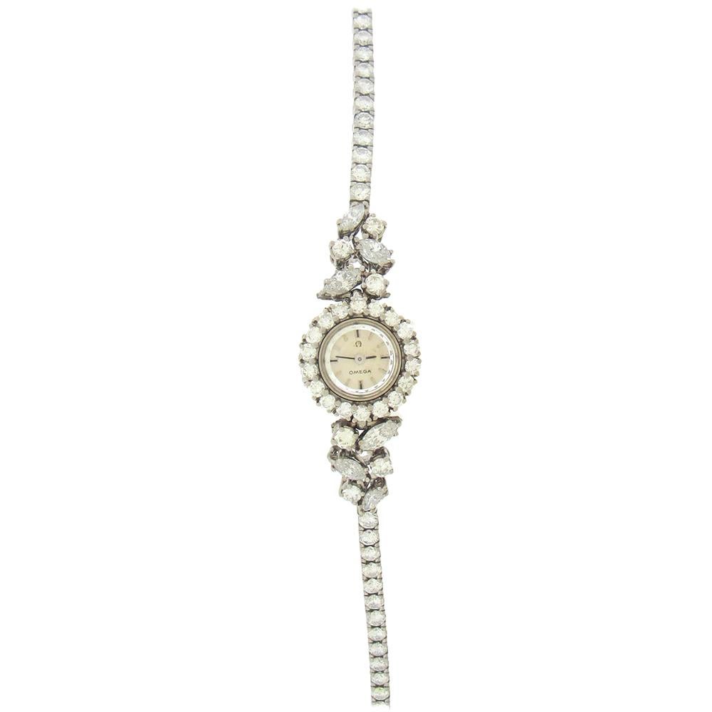 18K white gold diamond Omega women's backwind cocktail watch, circa 1960, has a 15mm case with round cut diamond bezel, extended flexible lugs set with marquise and round diamonds and a round diamond full bracelet, 6-3/4