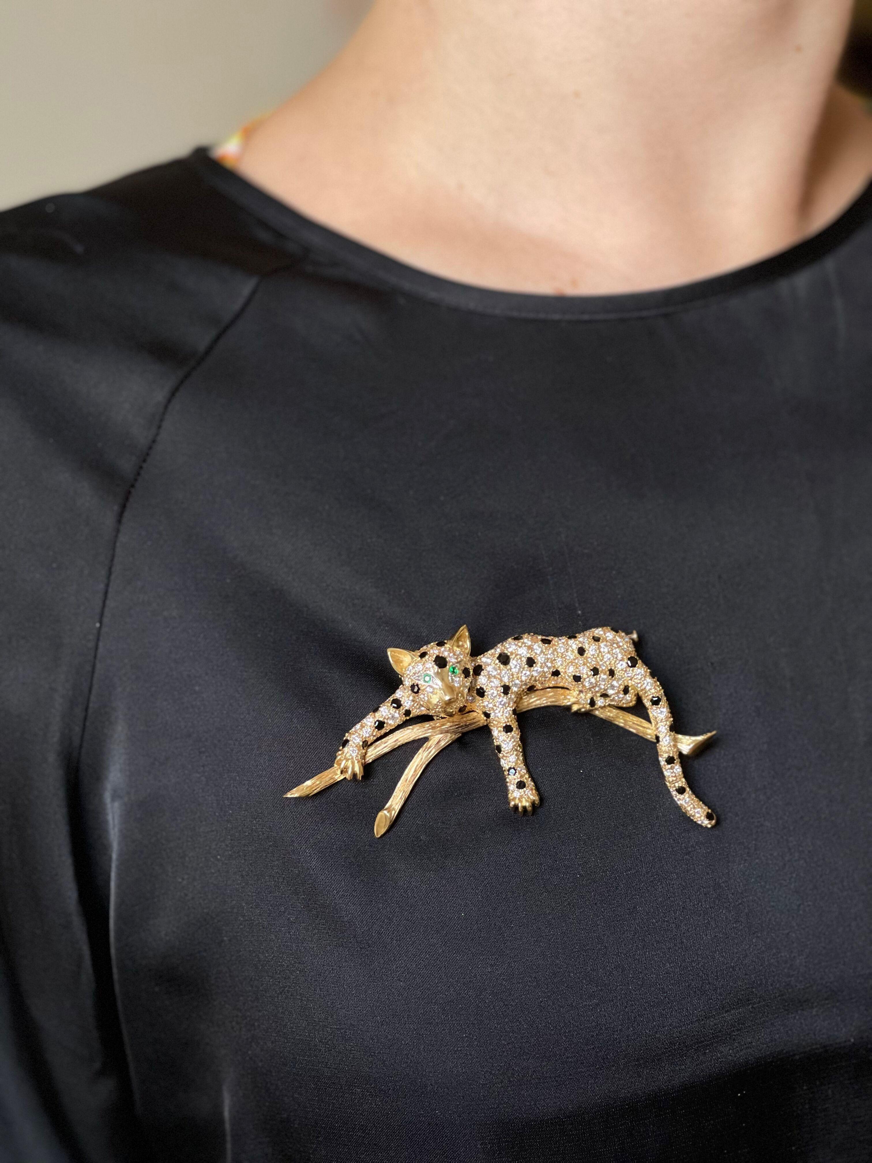 18k yellow gold leopard brooch, set with approx. 1.20ctw H/VS-Si diamonds, emerald eyes and onyx. The brooch measures 3.75