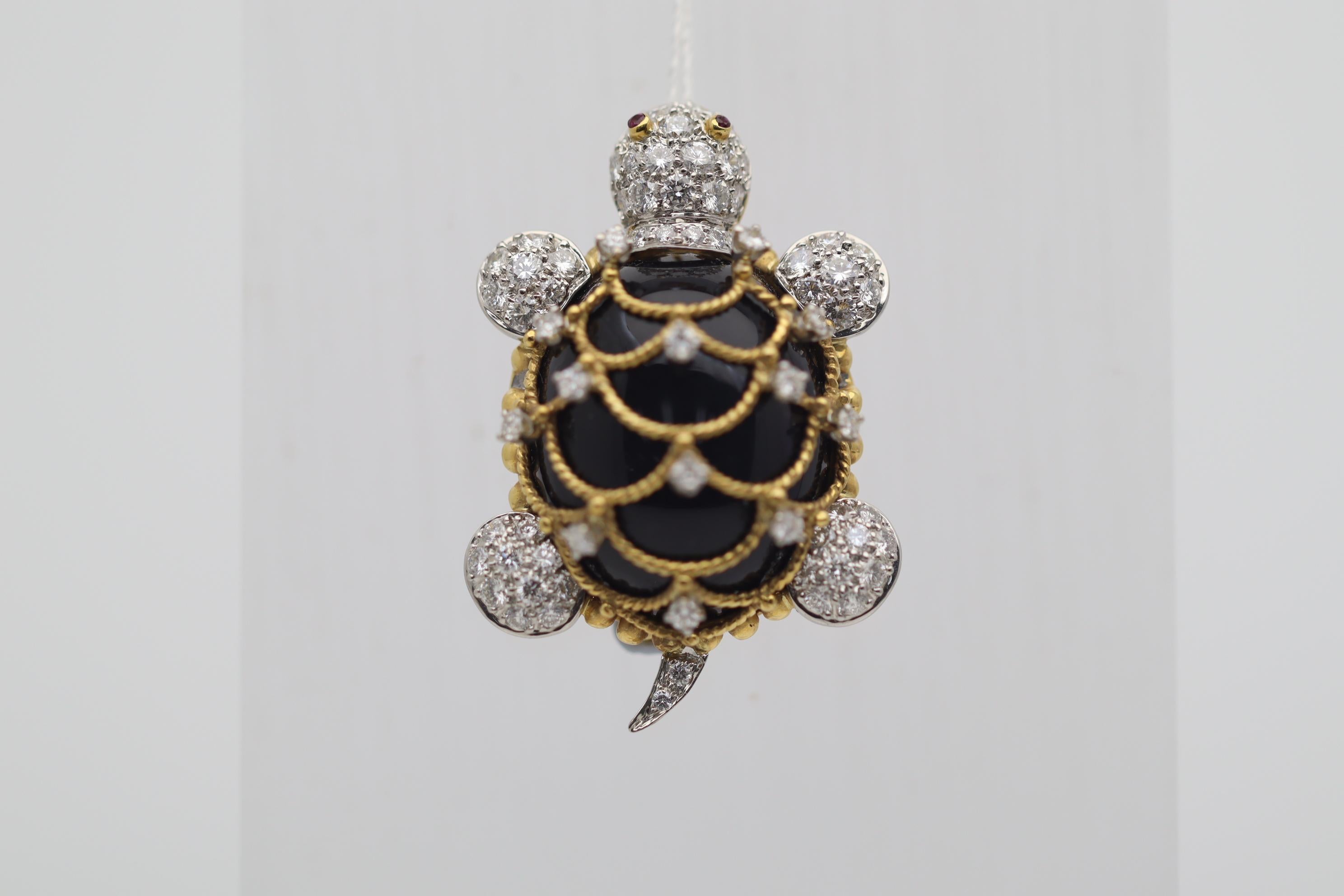 A super sweet and well-made diamond studded turtle brooch! Its shell is made of a single piece of polished black onyx which is webbed with stands of 18k yellow gold making the shell's pattern. Adding to that, 2.10 carats of round brilliant-cut