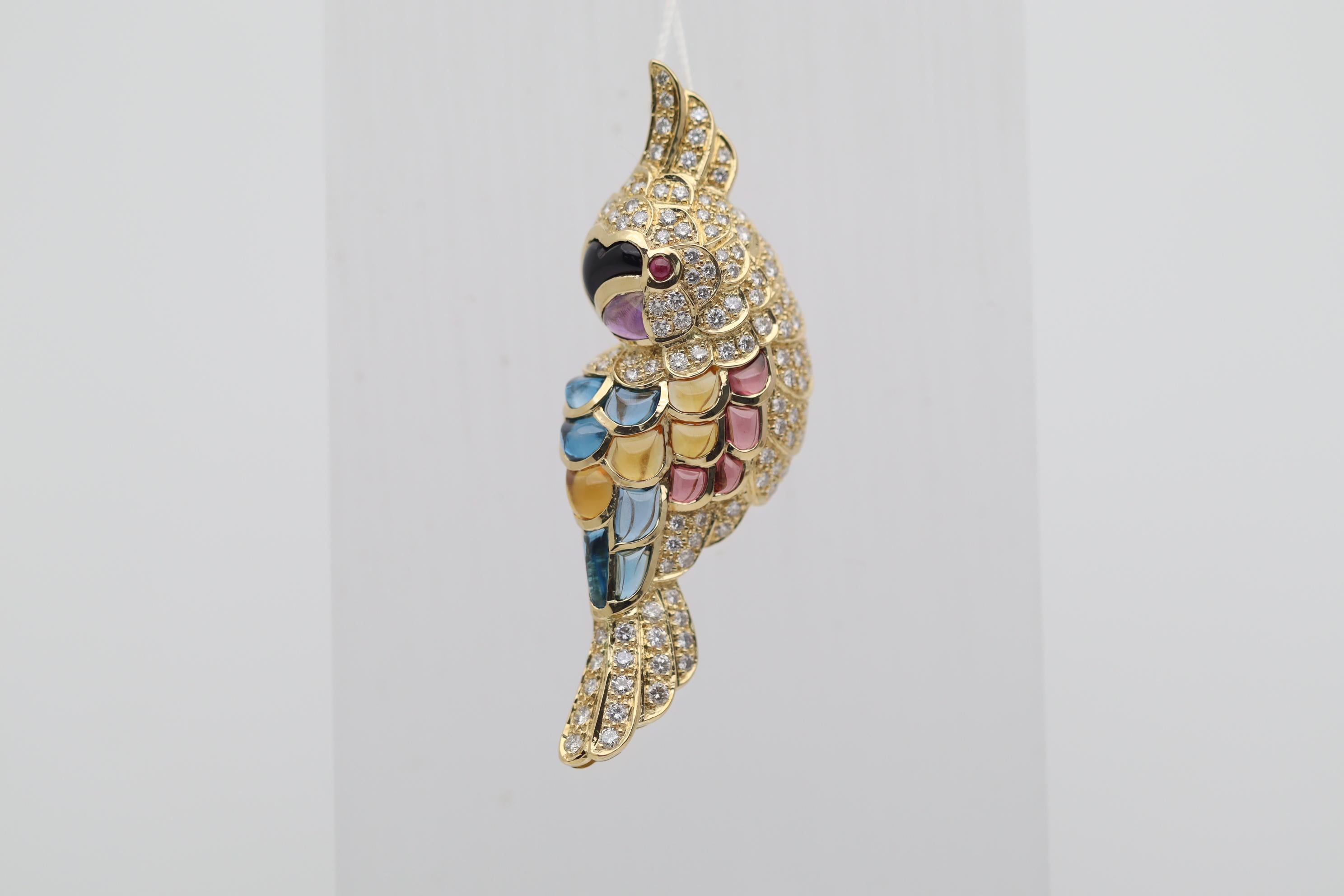 Ein süßer und eleganter Tukan, besetzt mit Diamanten und Farbedelsteinen, steht im Mittelpunkt! Der schöne Vogel ist mit 1,32 Karat runden Diamanten im Brillantschliff besetzt, die dem Schmuckstück Brillanz und Glanz verleihen, sowie mit