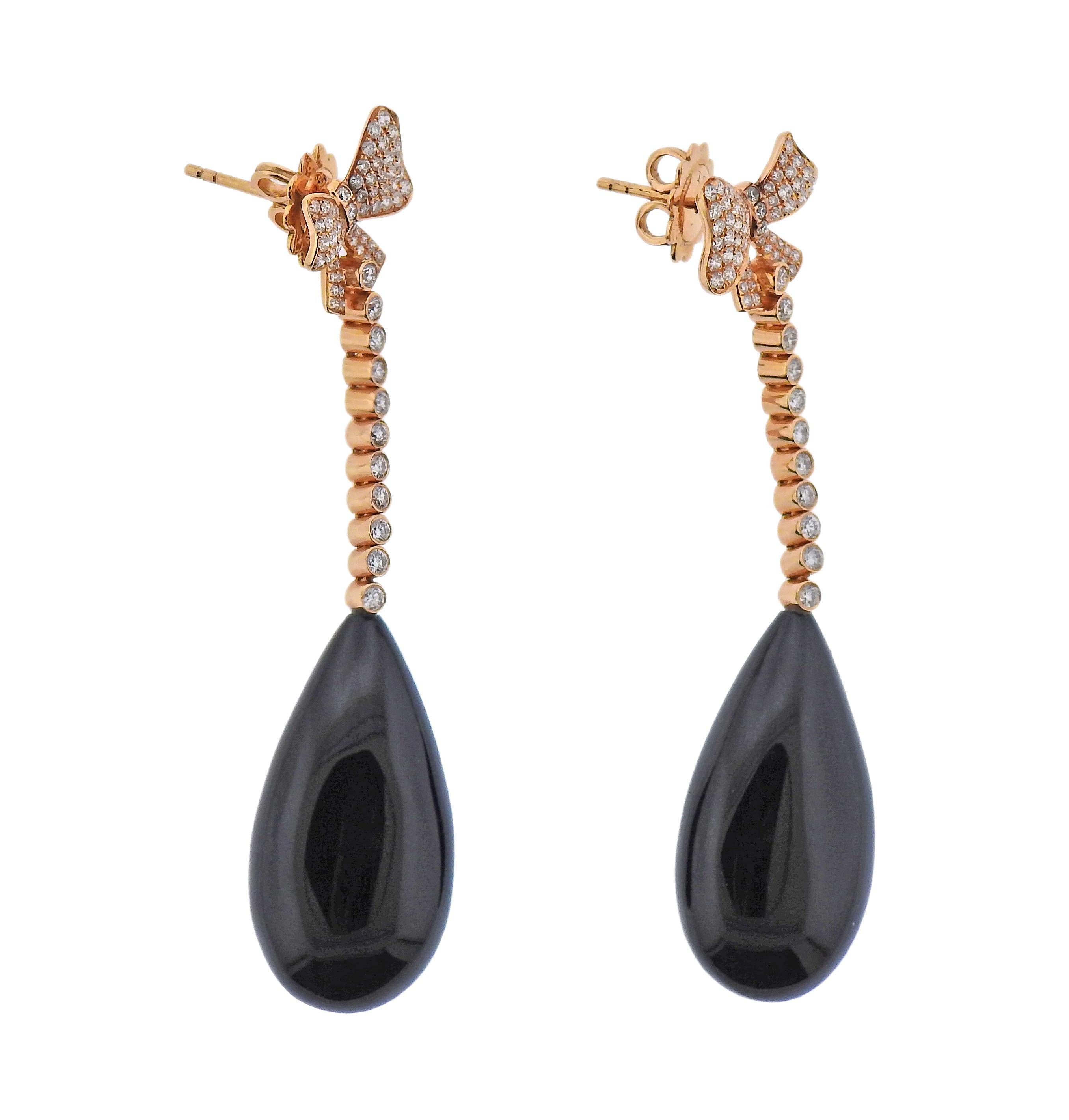 Pair of 18k rose gold drop earrings with bows. Set with teardrop onyx and approx. 0.80ctw in diamonds. Earrings are 62mm long. Marked 18k. Weight - 15.9 grams.