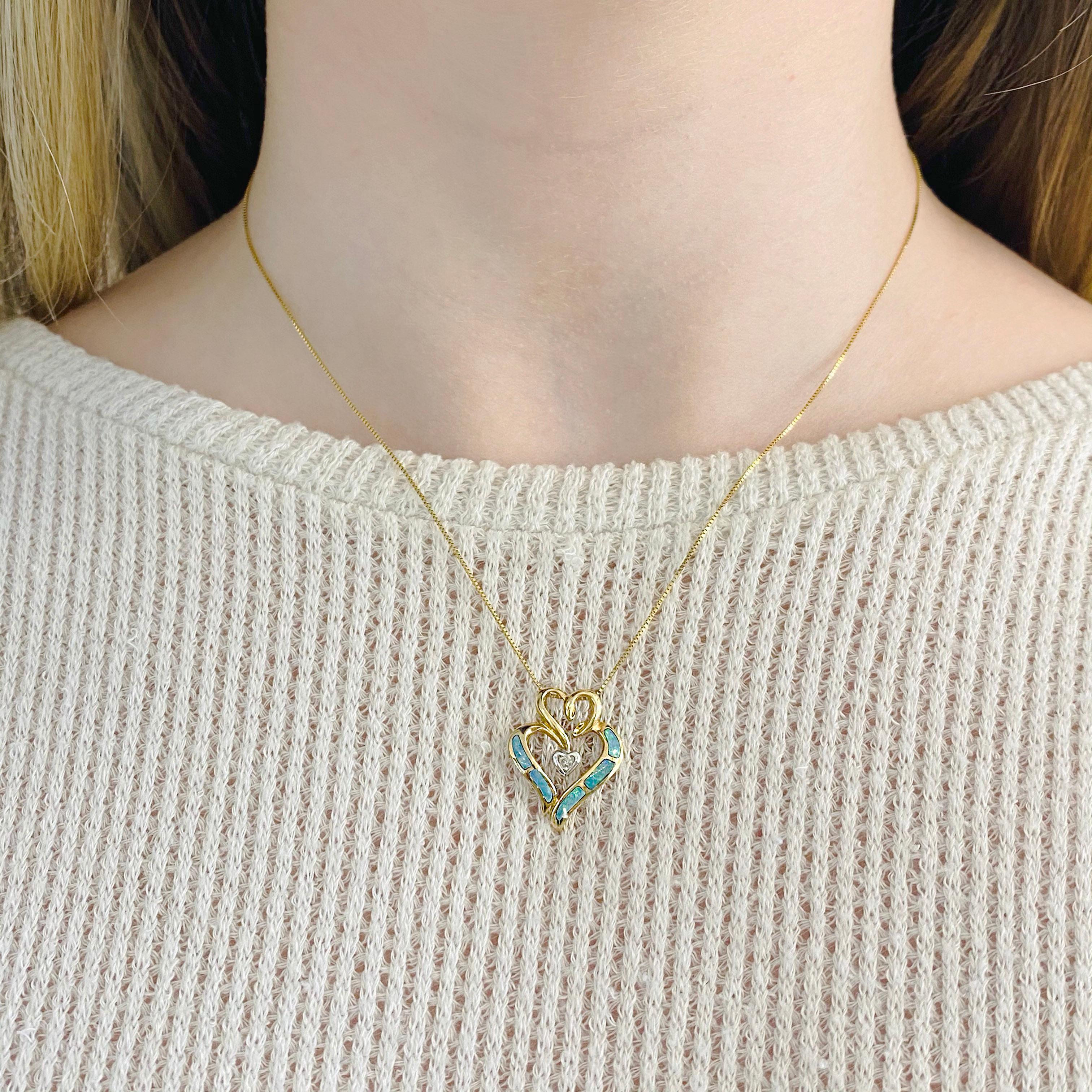 Dieser schöne dreifache Herzanhänger hat einen wunderschönen blau/tealfarbenen Opal, der in ihn eingelegt ist. Dieser dreifache Herzanhänger mit einem Diamanten als Akzent hat ein Herz aus Gelbgold, ein Herz aus Weißgold und ein Herz aus Opal, die