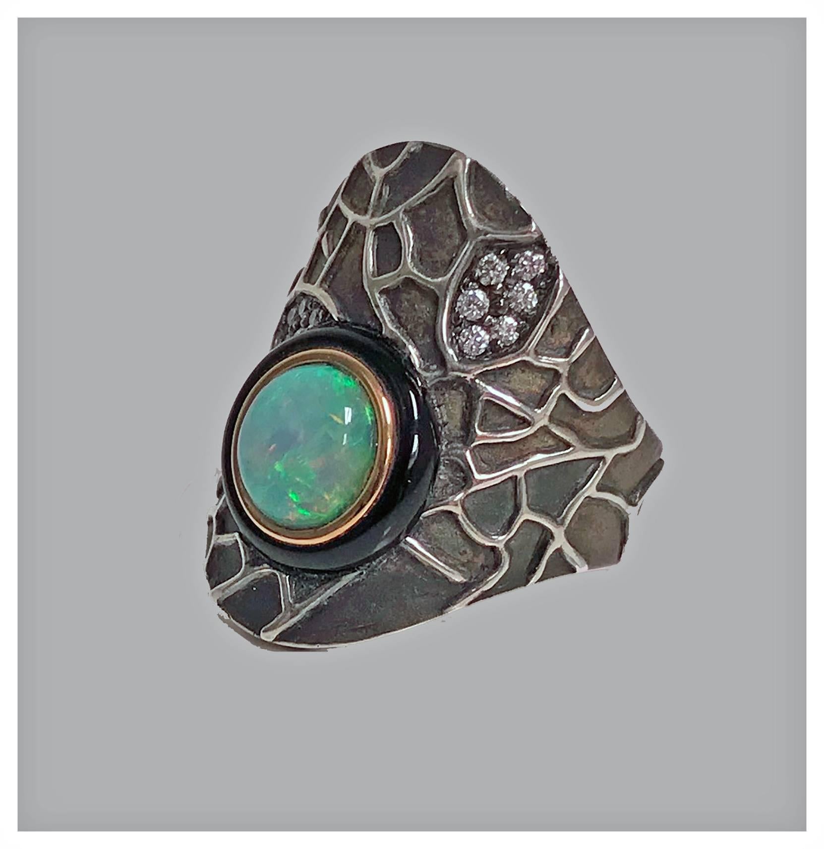Diamond opal onyx silver and gold ring, 20th century. The of an asymmetrical shape, 18-karat gold bezel offset with a round opal, approximately 8.00 mm, good play of color, with outer black onyx surround. The mount of oxidised silver with applied
