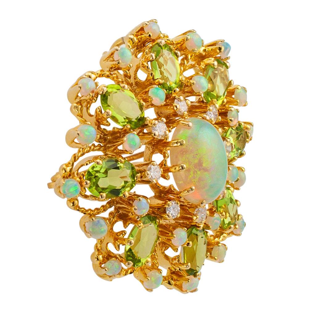 Diamond opal peridot and gold brooch pendant circa 1960. The open work starburst design features a larger oval opal encircled by diamonds, small round opals and oval peridot, the diamonds totaling approximately 0.45 carat, approximately H – I color