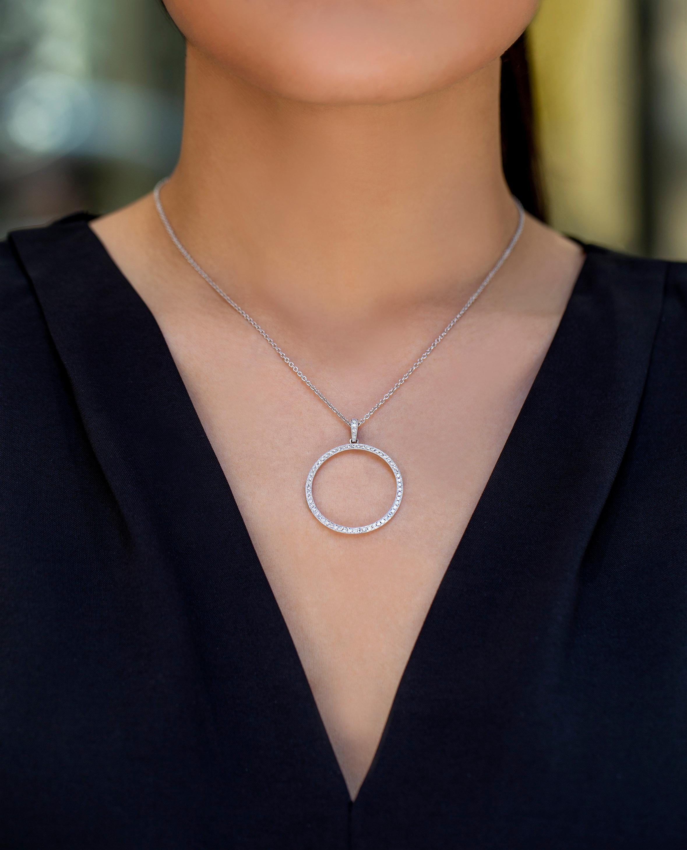 A simple pendant necklace showcasing a diamond encrusted circle pendant weighing 0.64 carats total, pave set with milgrain edges, with diamond encrusted bail. suspended on 18 inches white gold chain, Made in 18k White Gold.

Style available in
