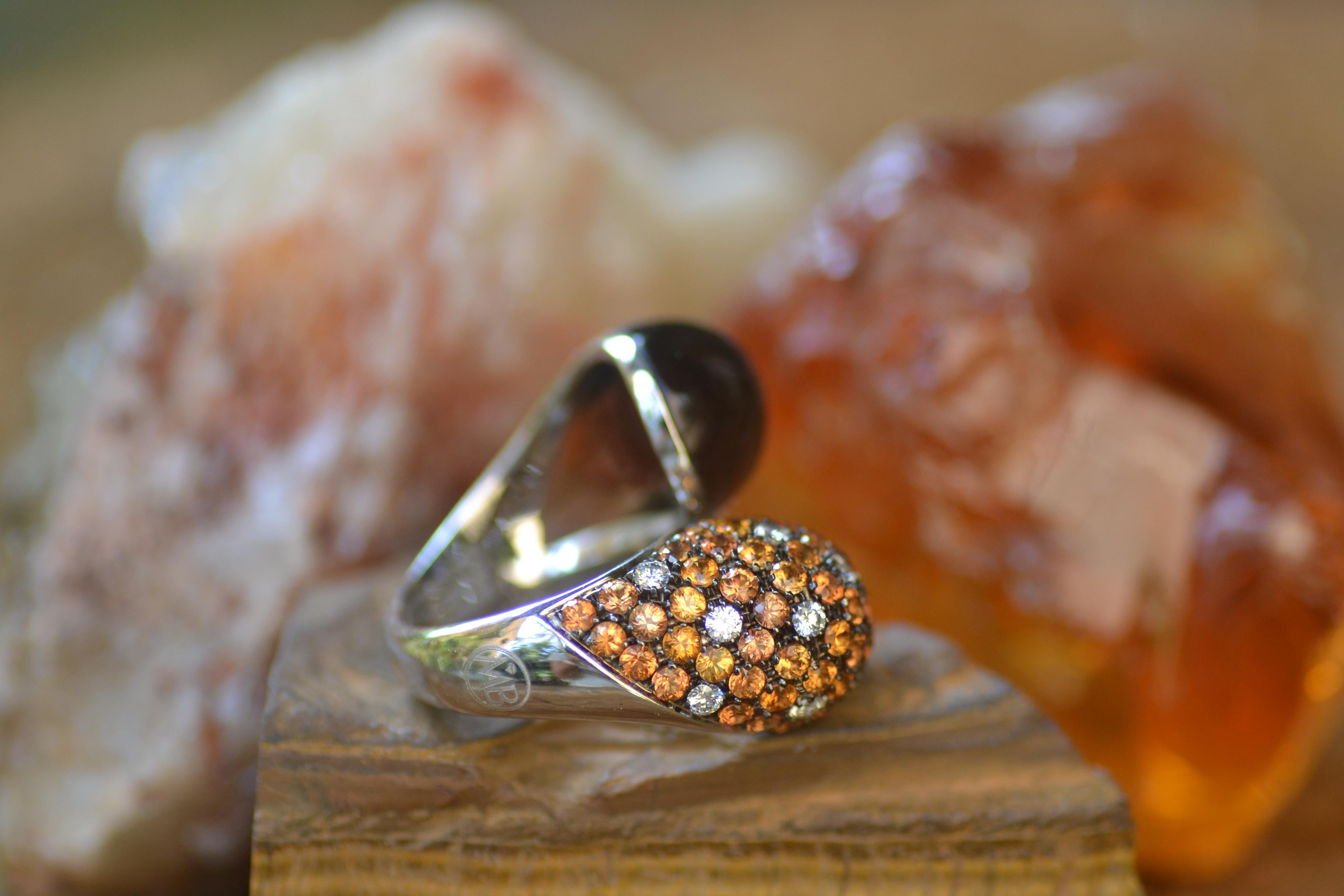 Handcrafted in Margherita Burgener family workshop in Valenza, Italy, this ring is very comfortable and stylish.
One side is full pavé set in orange sapphires with spots of diamonds, while opposite side is a cabochon cut smoky quartz

18 KT white 
