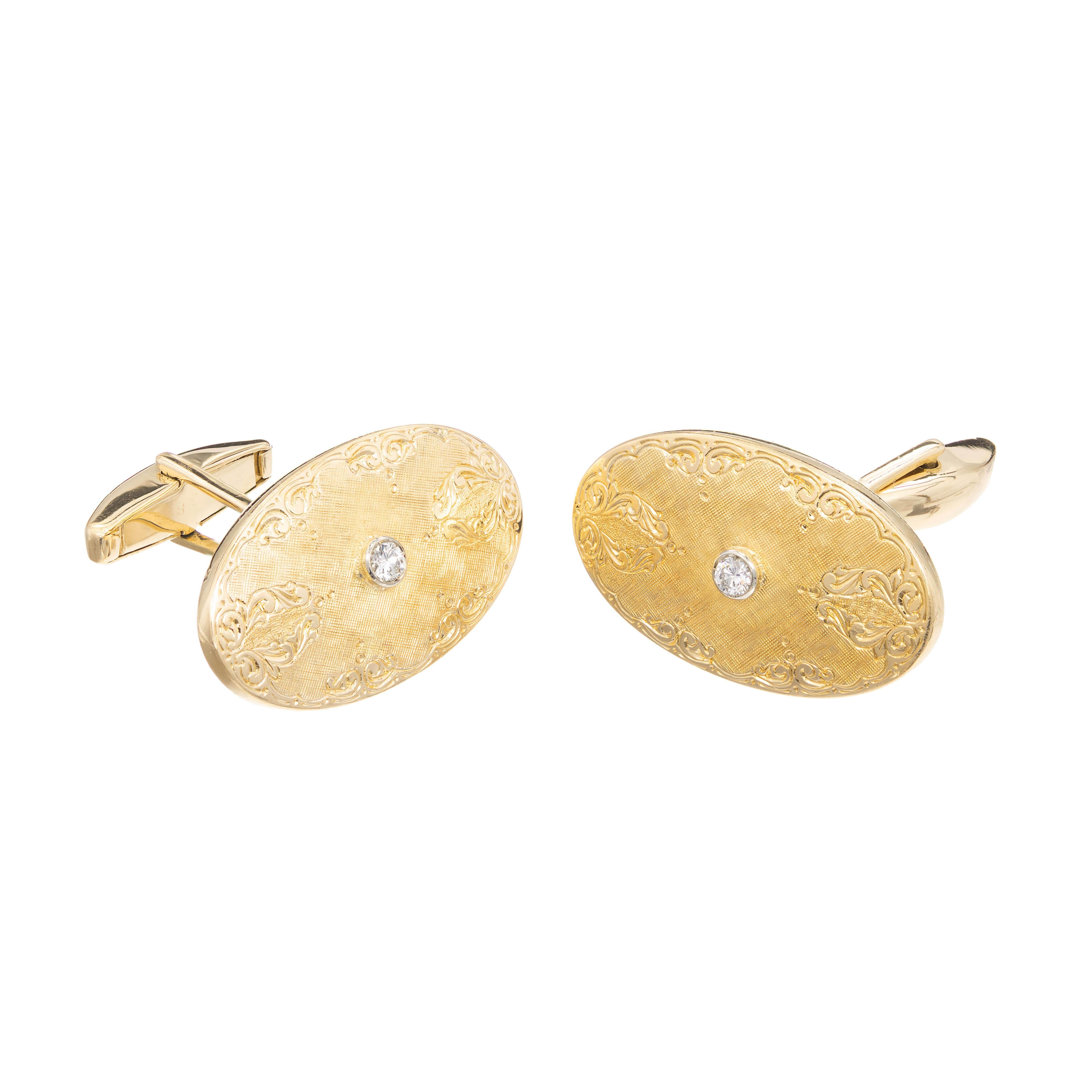 Diamond 18k Yellow gold oval shaped cufflinks. A round diamond is bezel set in a 18k white gold setting and placed in the center of the 18k yellow gold oval with engraving and etching design with a high polish outside.

2 round brilliant cut H-I VS
